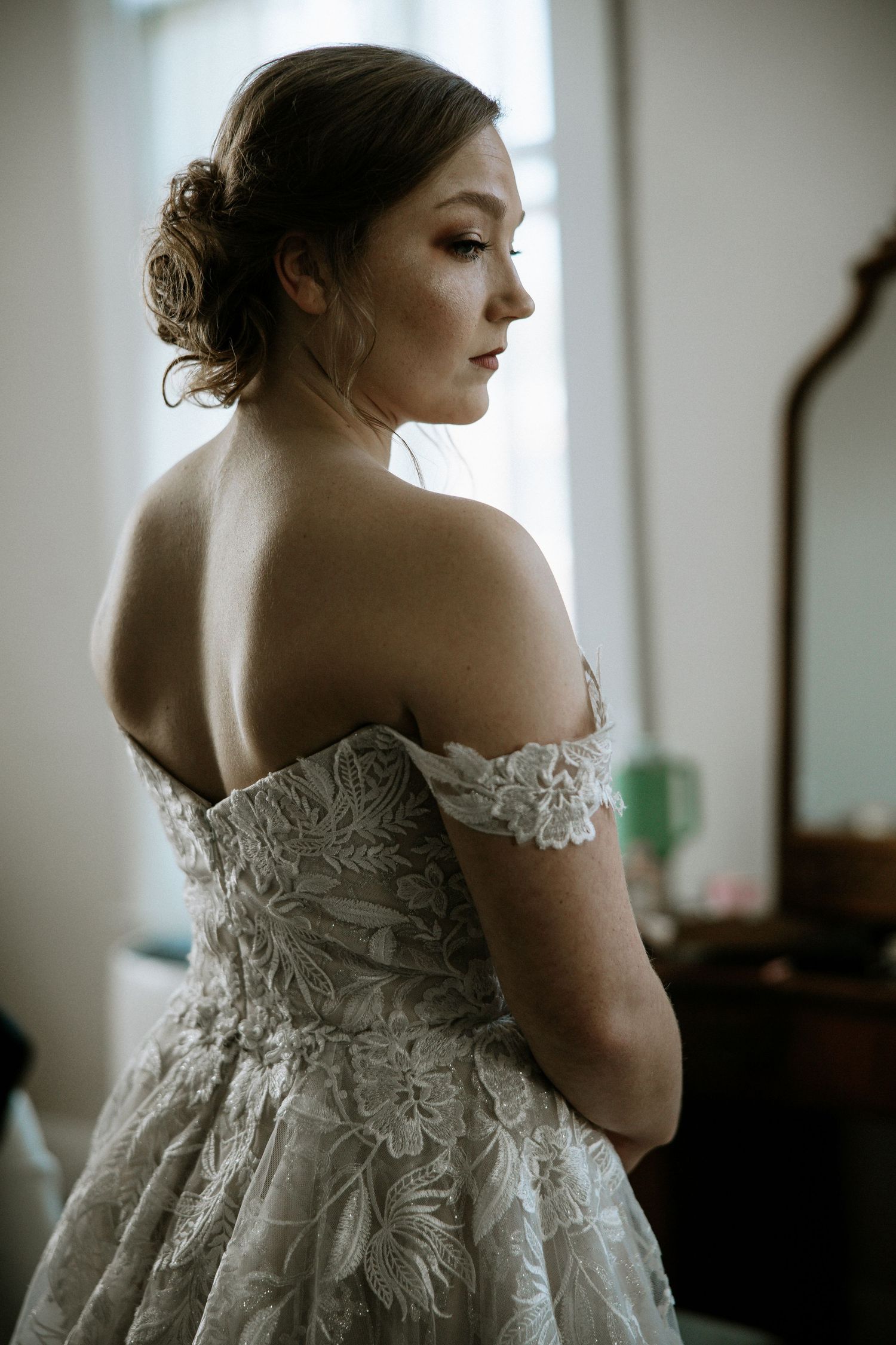 Bride in elegant off-shoulder lace wedding gown with floral embroidery at Urban Artifact in Cincinnati, Ohio