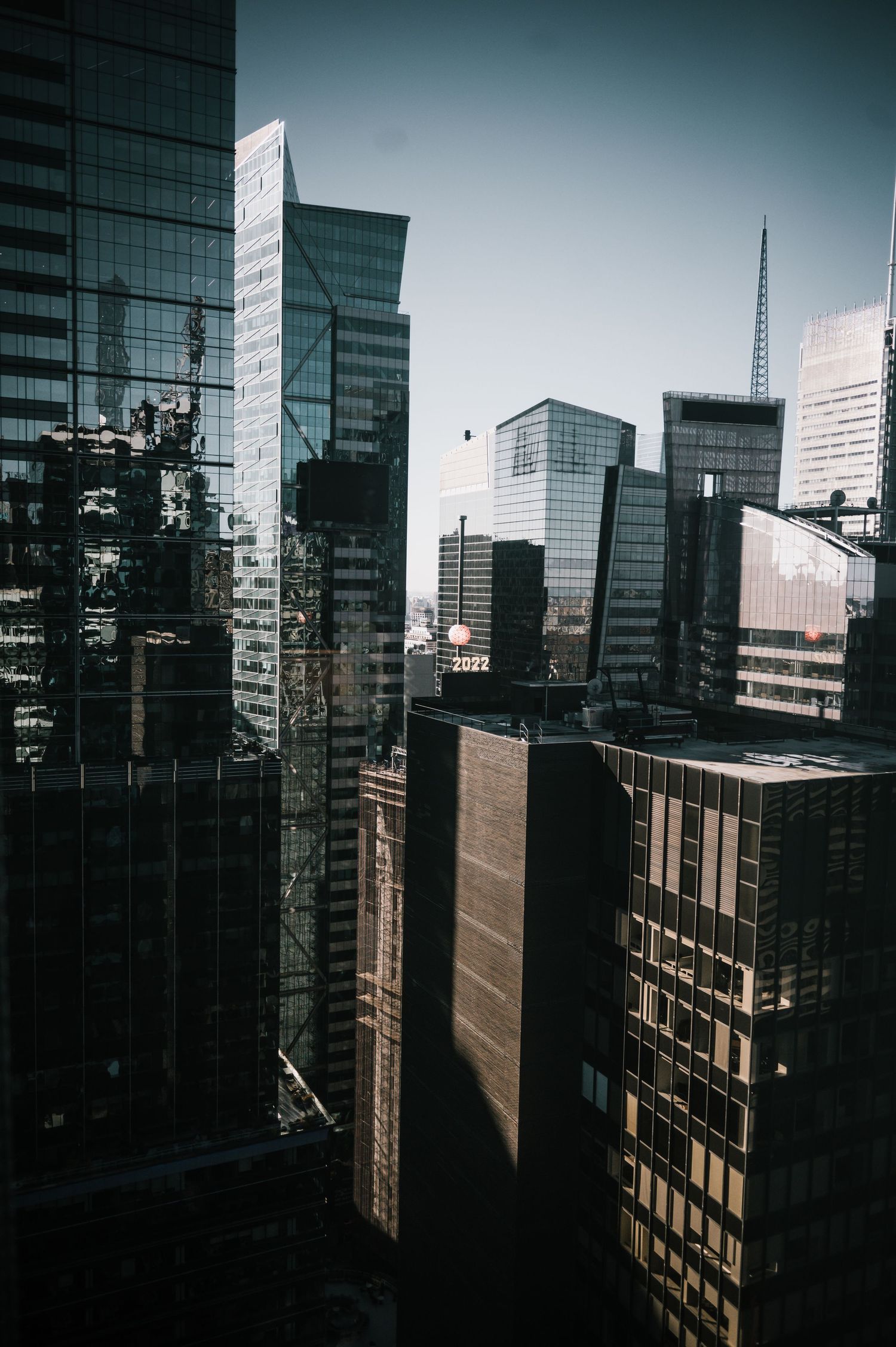 Urban cityscape with modern glass skyscrapers against a clear blue sky.