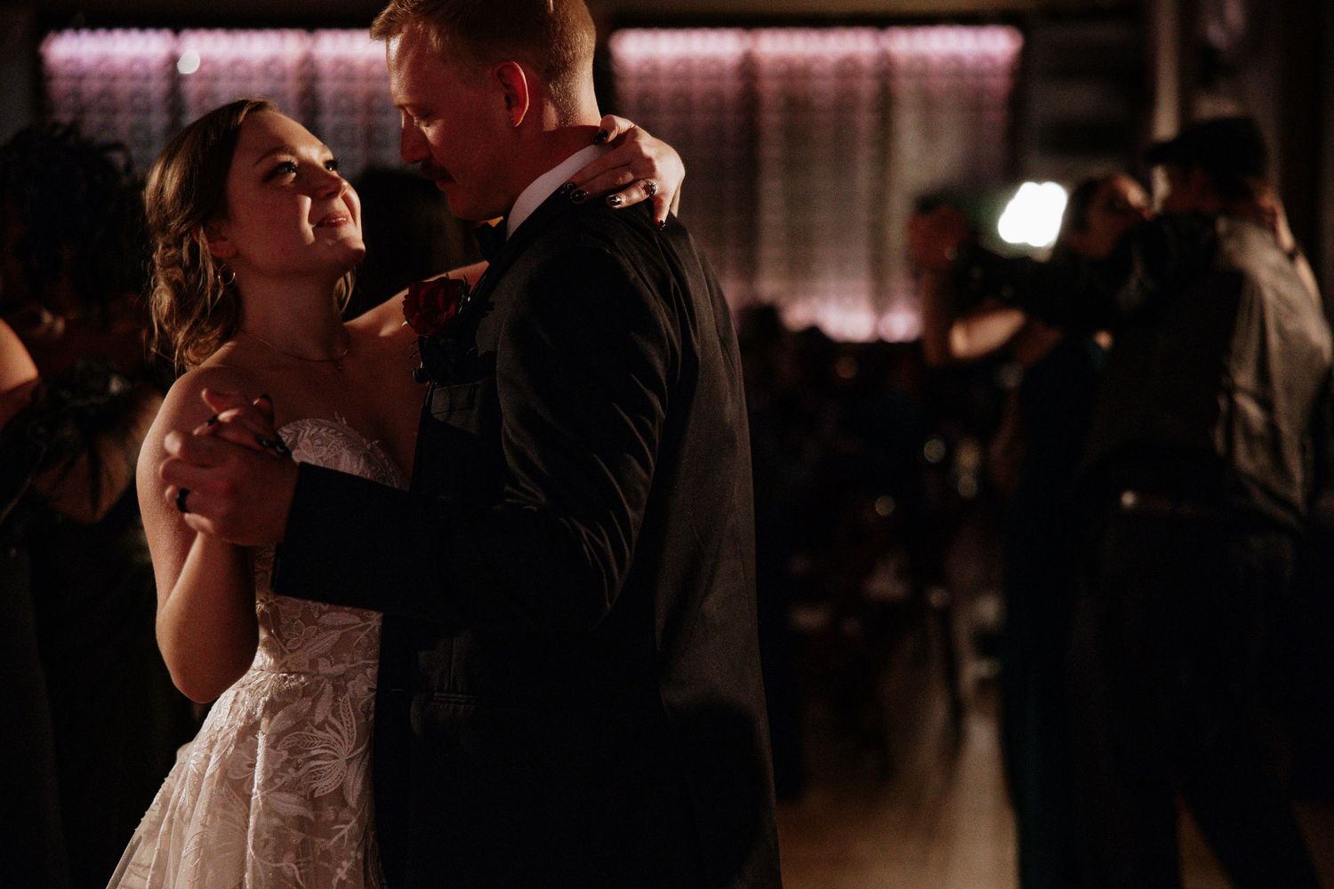 Bride and groom sharing an intimate first dance in a softly lit wedding reception venue at Urban Artifact in Cincinnati, Ohio