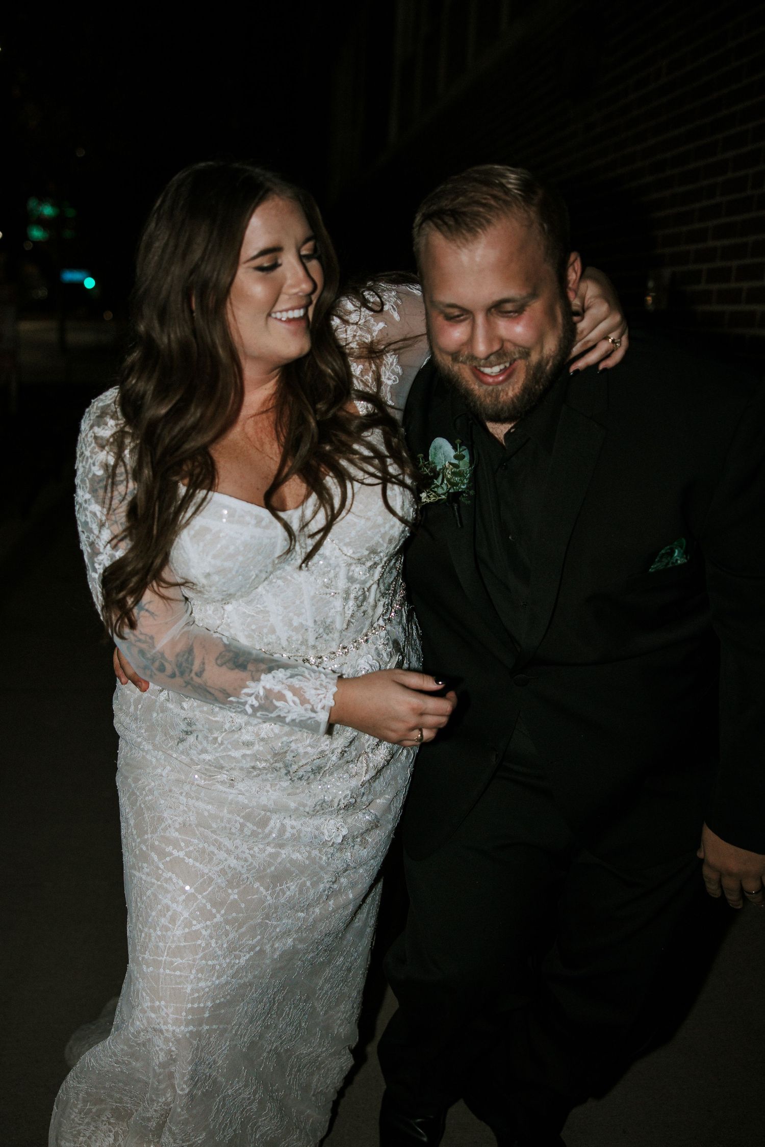 Bride and groom laughing together outside at night after wedding reception at The Red Space in Cleveland, Ohio