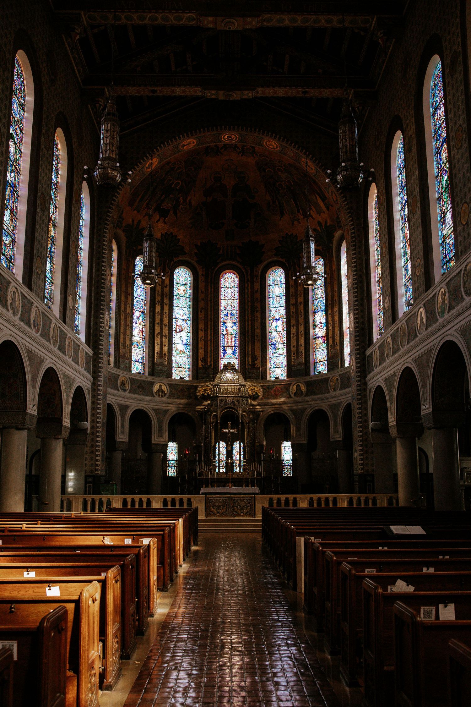 Stunning Gothic church interior with ornate stained glass windows, wooden pews, and elaborate altar mosaic in Cincinnati, Ohio