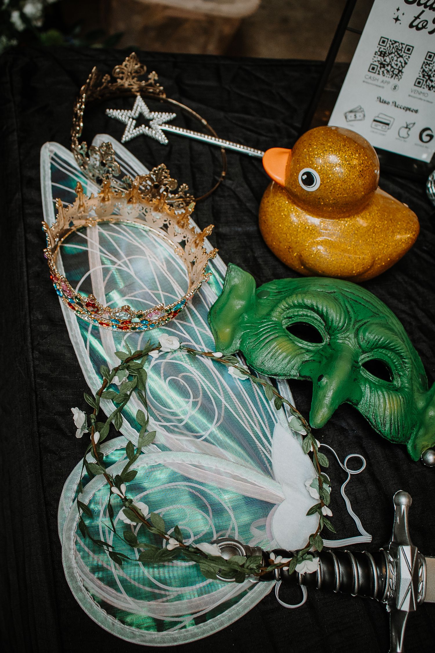 Fairy costume accessories including wings, crown, green mask, star wand, leaf wreath, dagger, and gold glitter rubber duck.