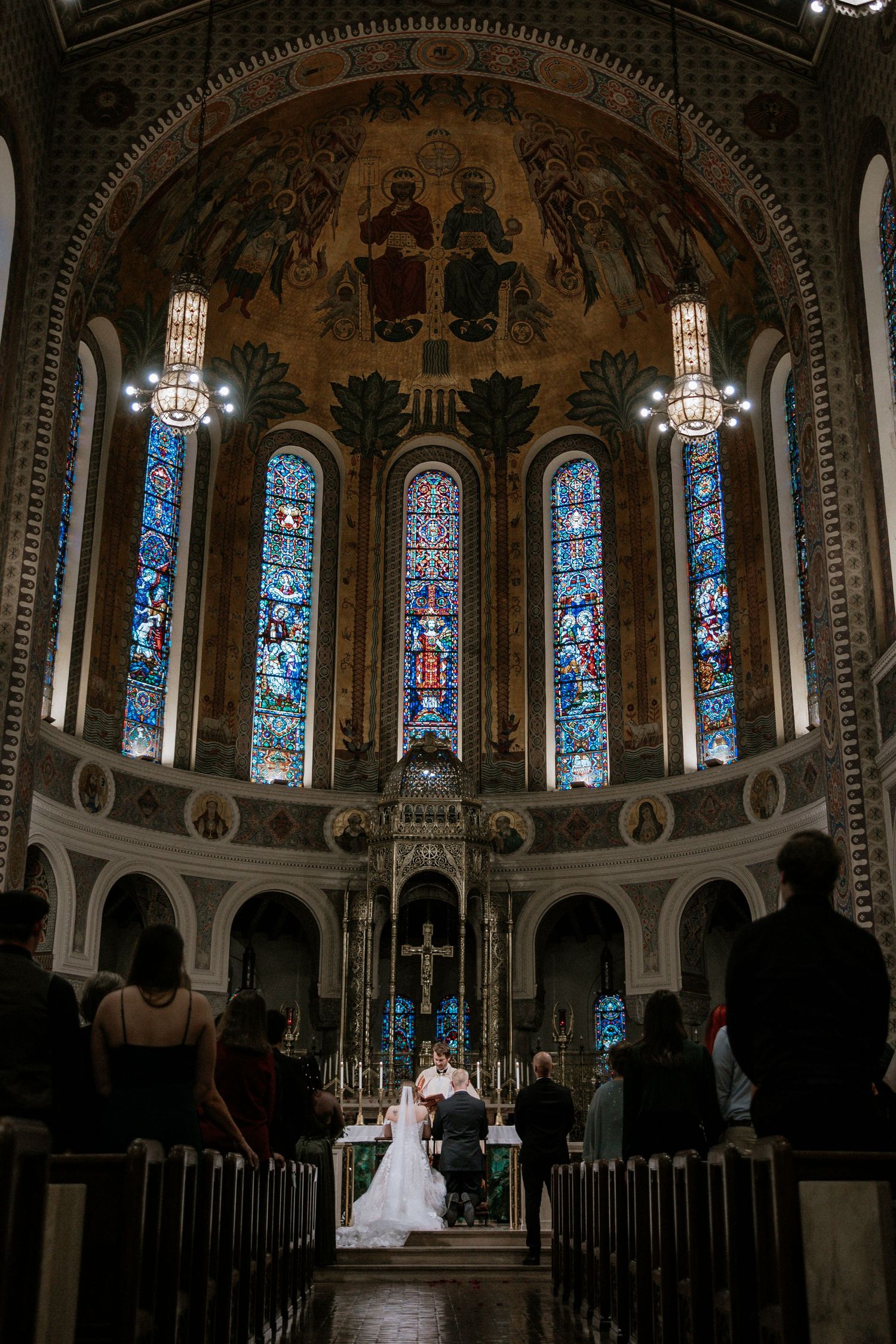 Elegant church wedding ceremony with ornate altar, stained glass windows, and guests seated in wooden pews in Cincinnati, Ohio