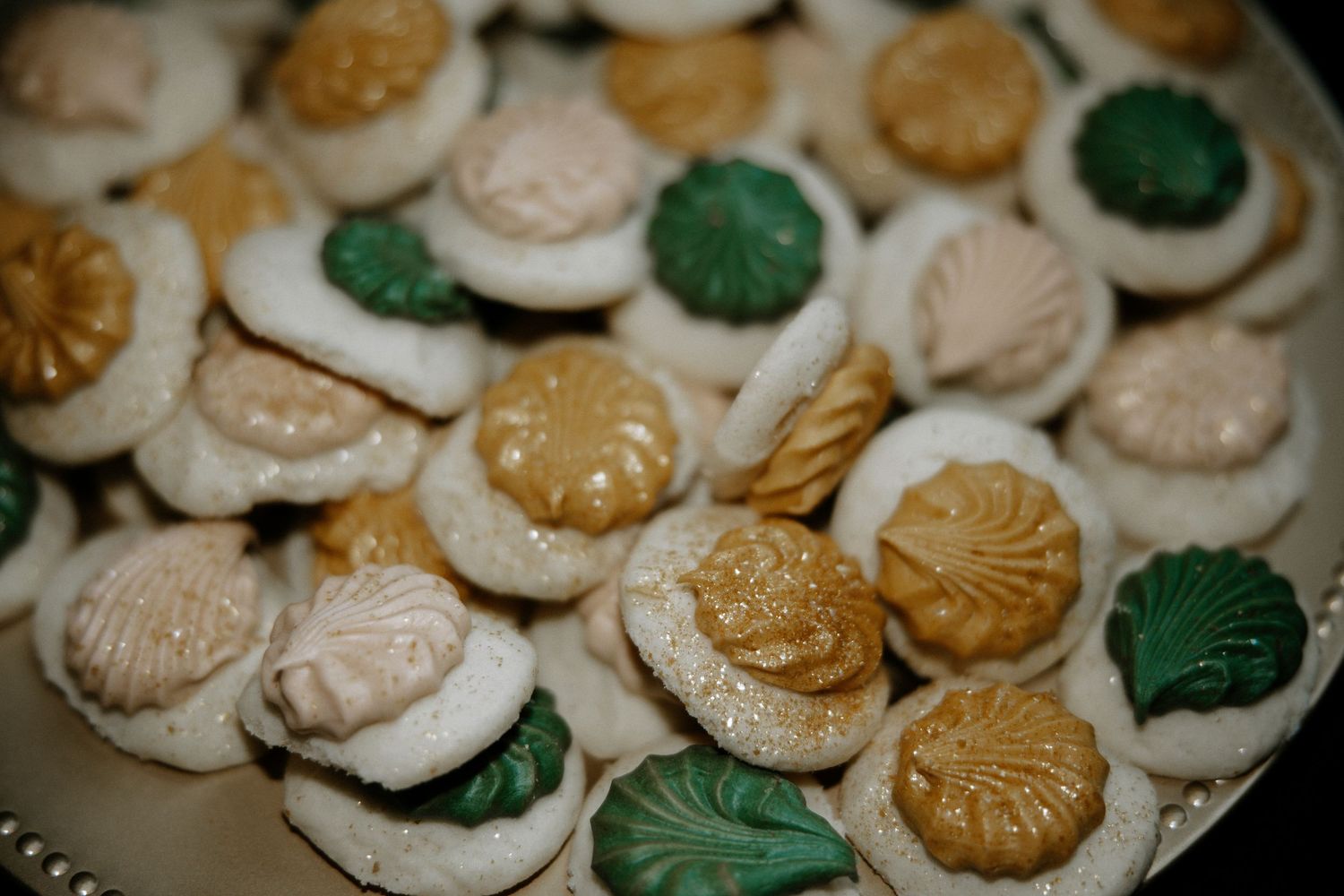 Assorted decorative pastel and gold molded butter mint candies arranged on a silver serving platter at Urban Artifact in Cincinnati, Ohio