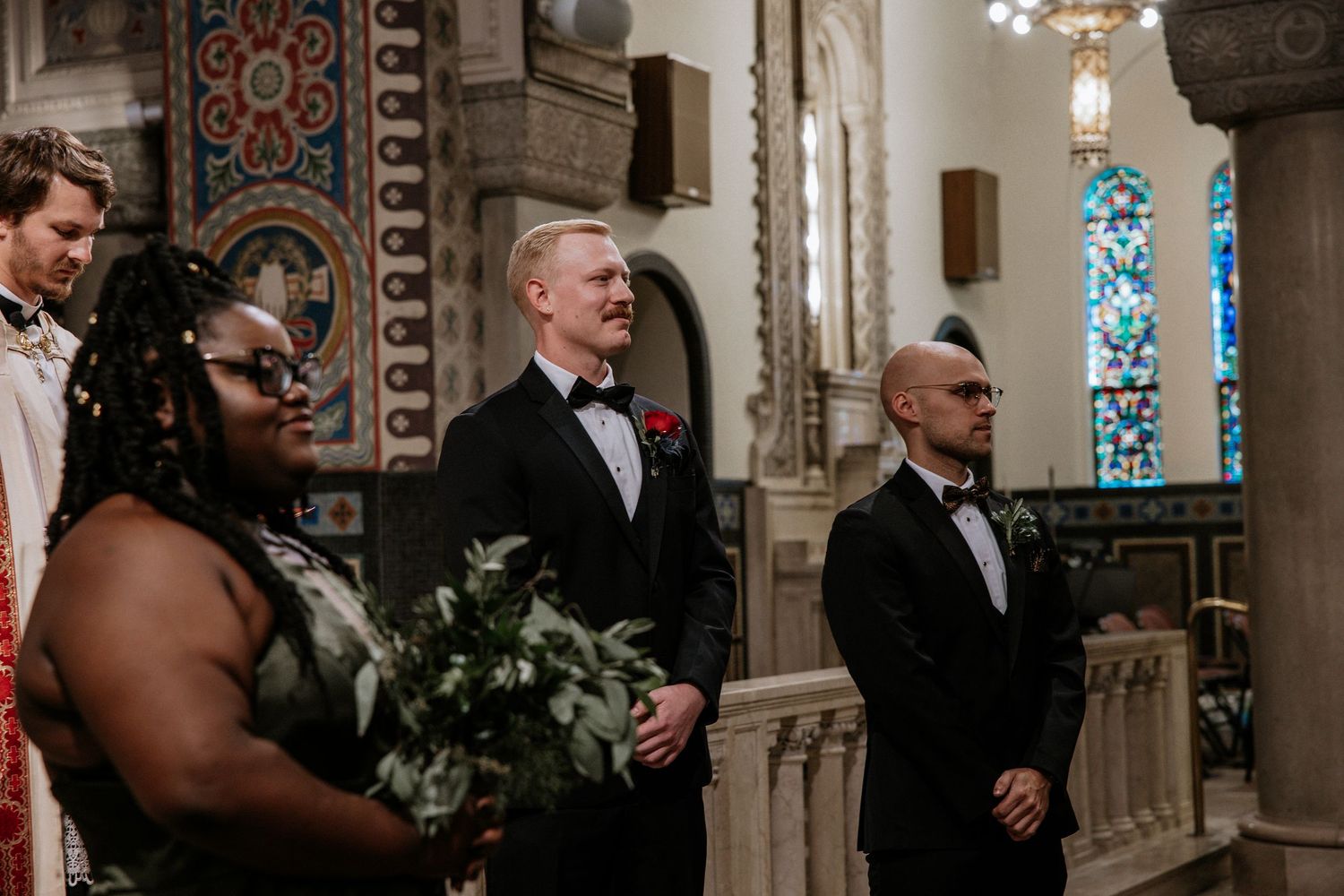 Wedding party stands at church altar as groom in tuxedo smiles joyfully during ceremony in Cincinnati, Ohio