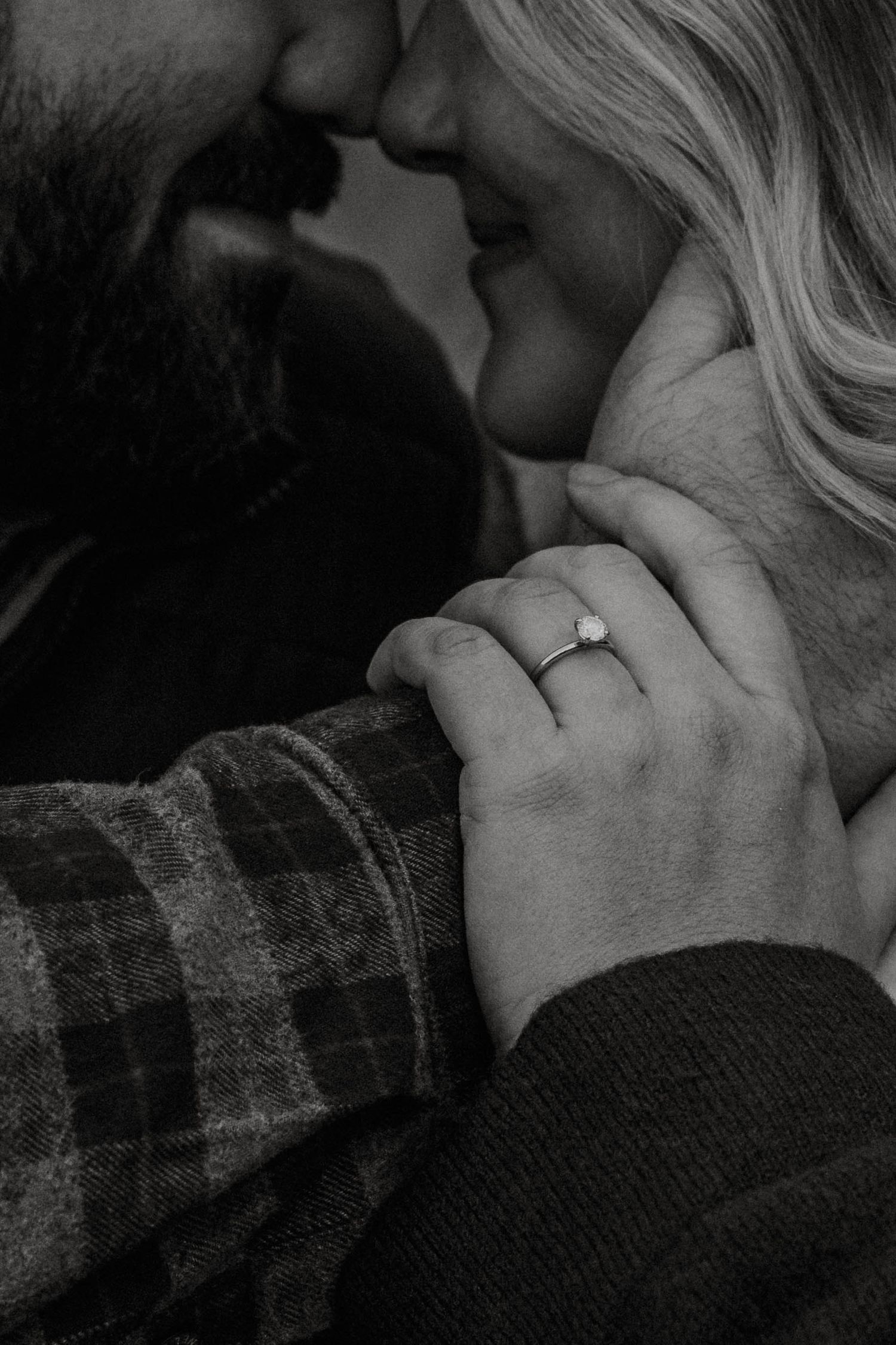 Black and white photo of a couple about to kiss, woman wearing a diamond engagement ring at Oakes Quarry Park in Dayton, Ohio