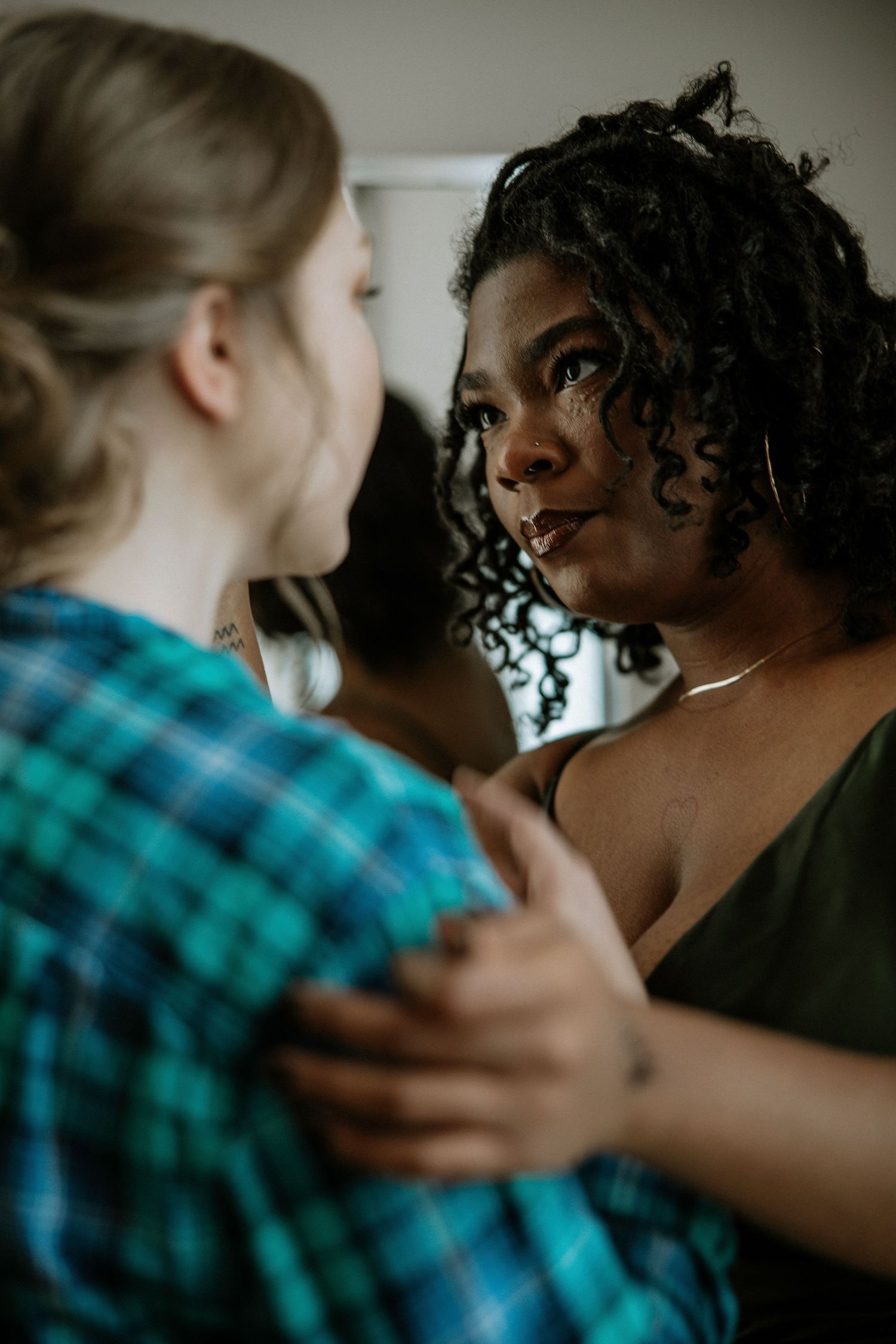 Two women sharing an emotional moment embracing each other during wedding preparations at Urban Artifact in Cincinnati, Ohio