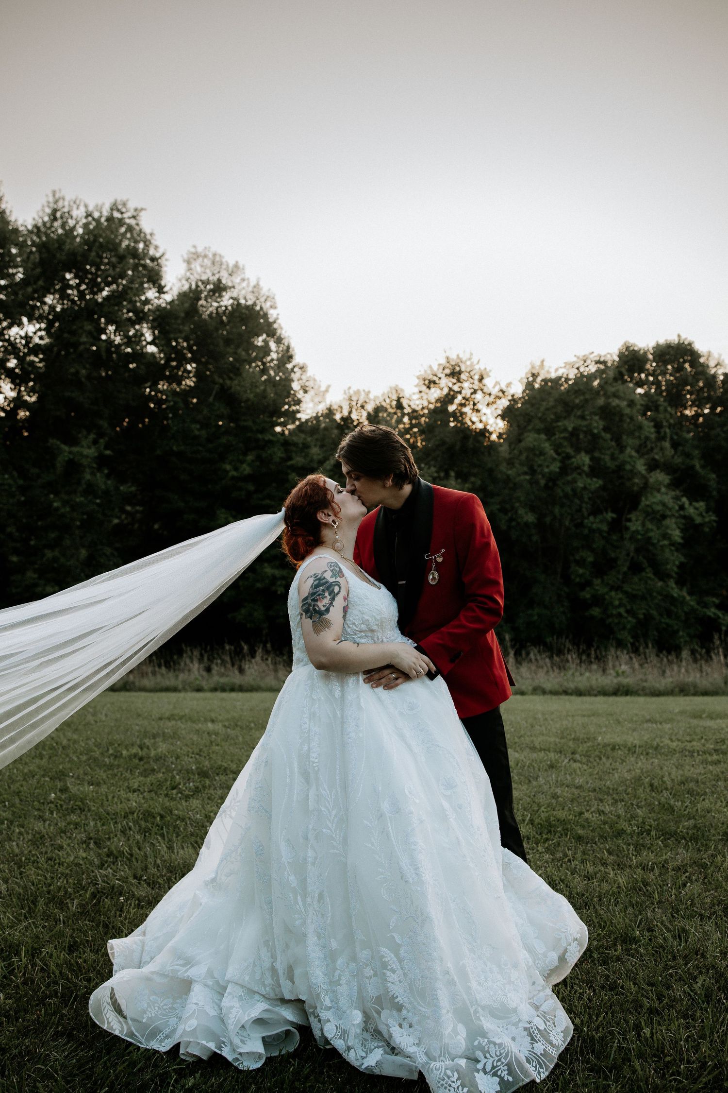 Bride and groom sharing romantic kiss outdoors at sunset at the Bella Amore on Enchanted Acres in Dennison, Ohio