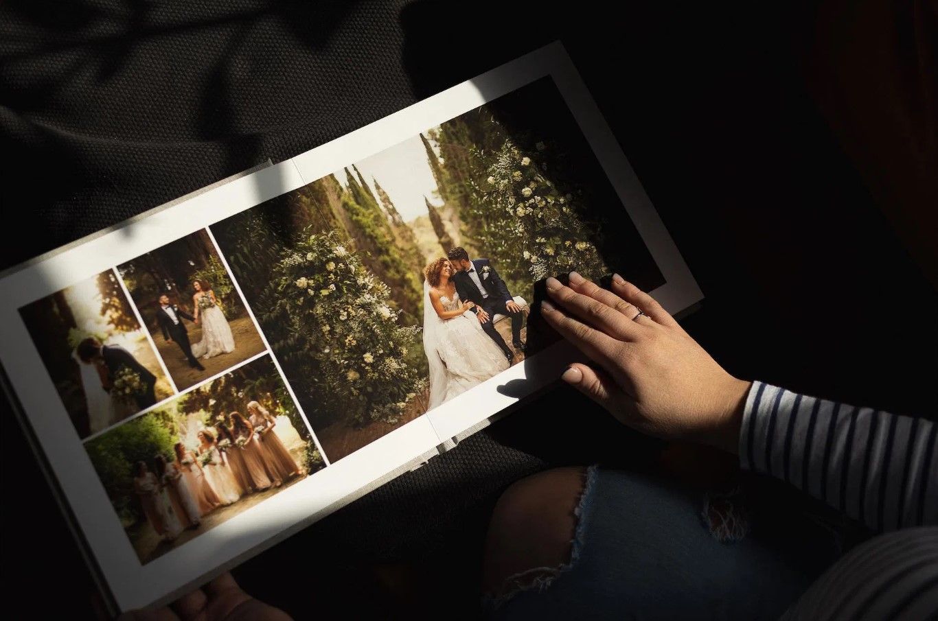 Bride and groom wedding photos displayed in an open album being held by a person in striped shirt in Cincinnati, Ohio