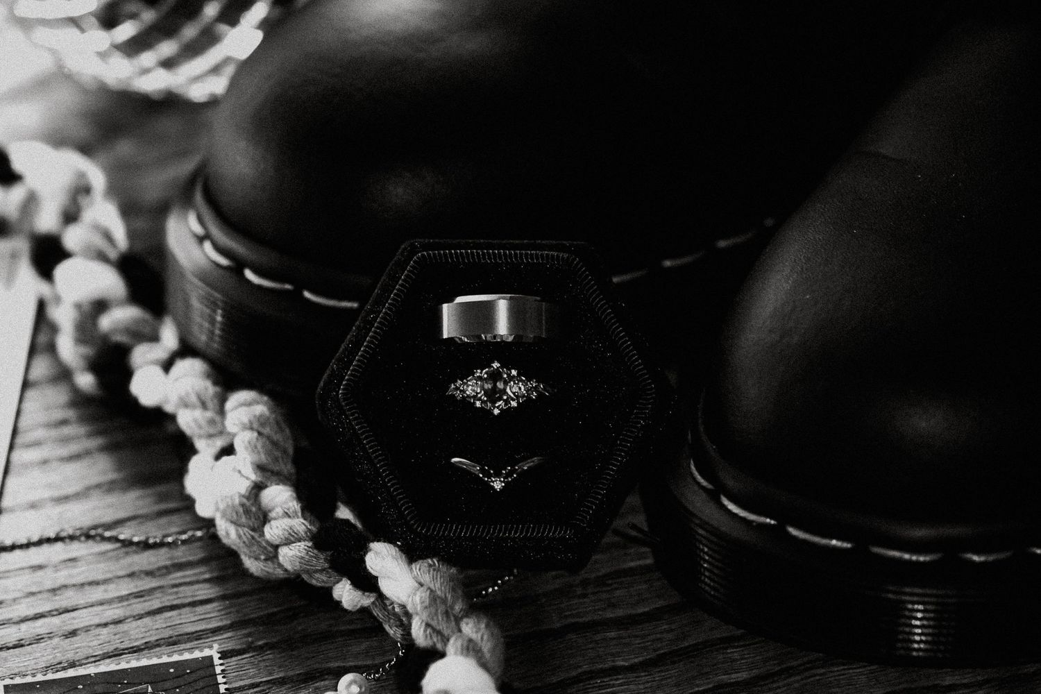 Black and white photo of wedding rings in a hexagonal velvet box beside Dr. Martens boots in Dayton, Ohio
