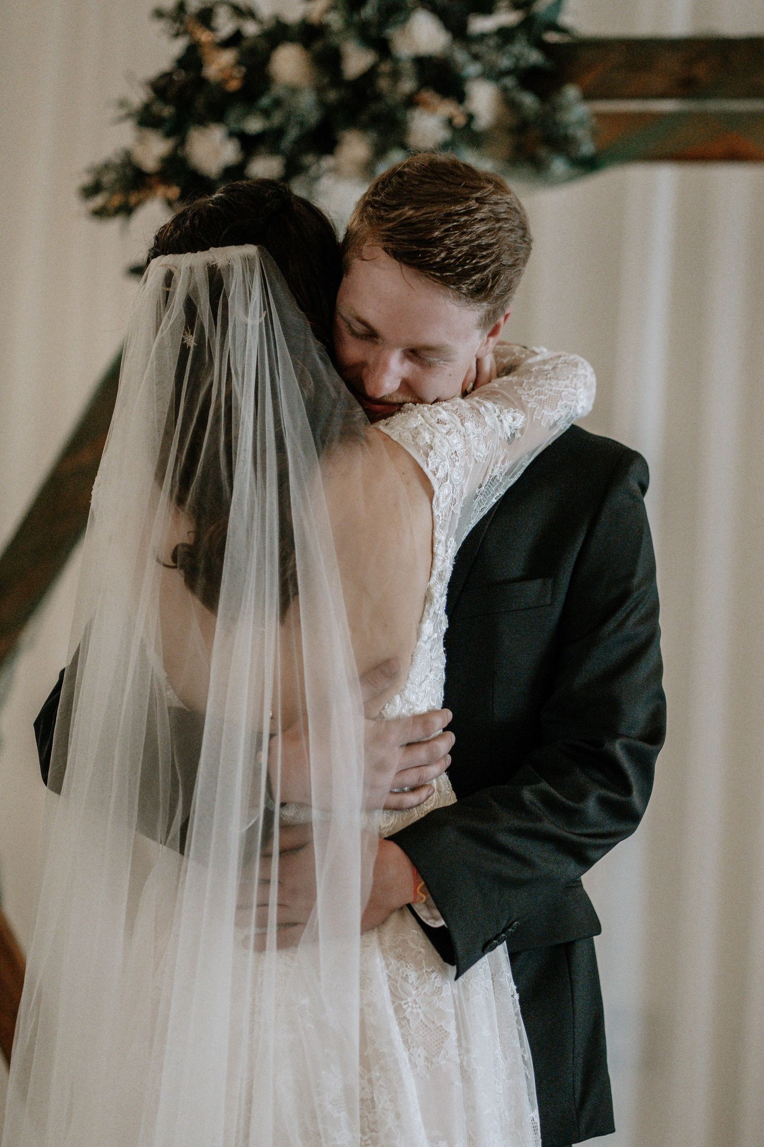 Bride and groom sharing an emotional first hug at the altar during their wedding ceremony.