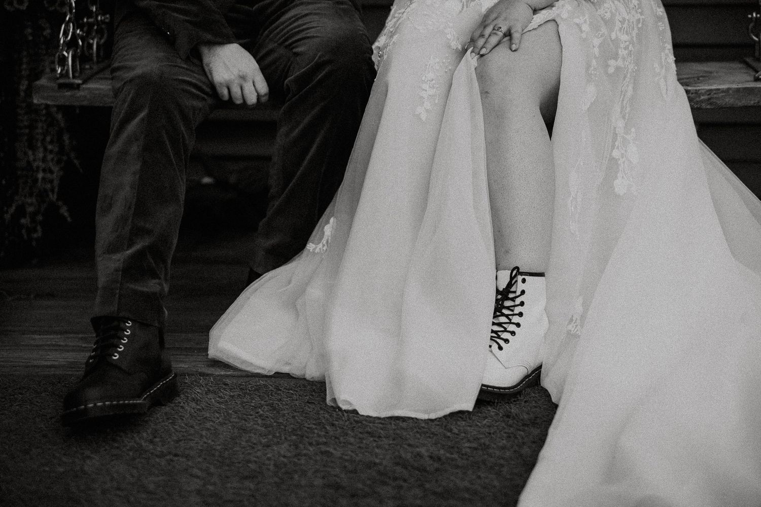 Black and white wedding photo of bride in lace gown with combat boots beside groom in dark suit and boots at The Brightside in Dayton, Ohio