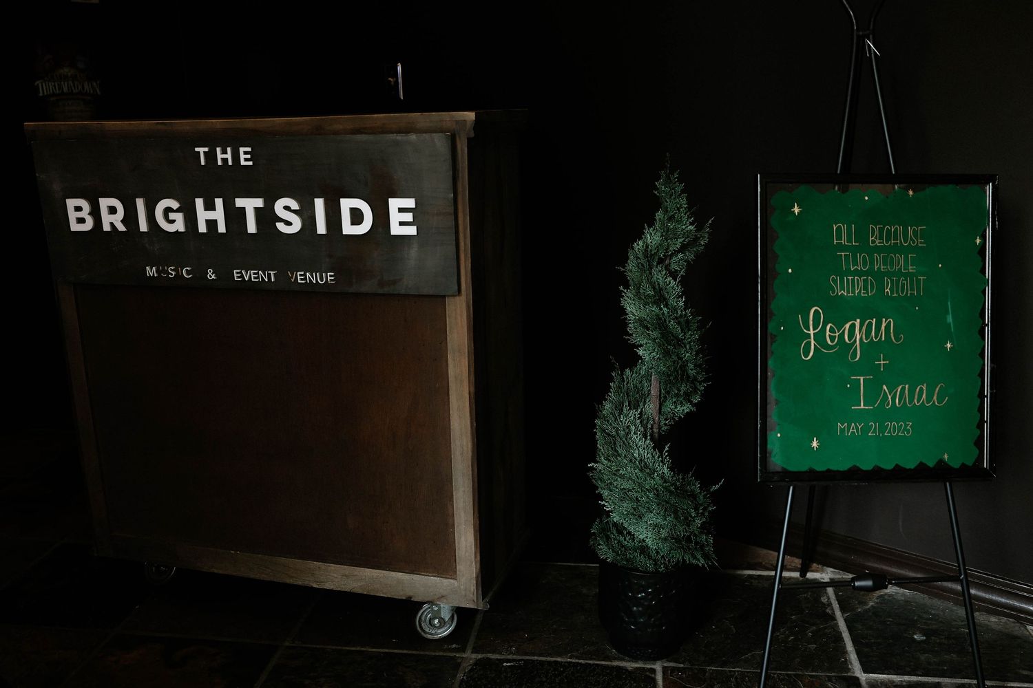 The Brightside NYC event venue sign beside a green wedding welcome board for Logan and Isaac.