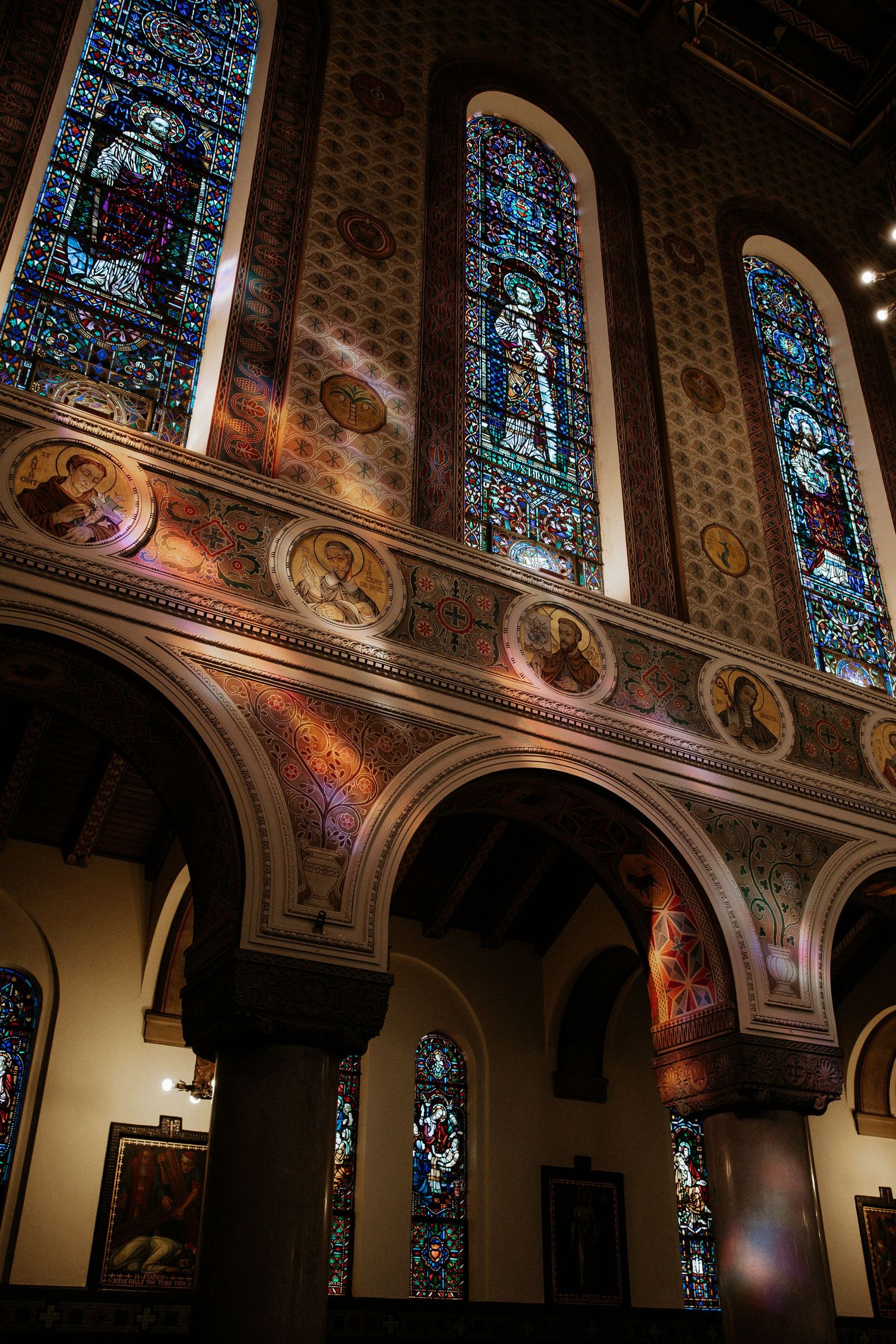 Ornate church interior with colorful stained glass windows and decorative mosaic walls bathed in warm light in Cincinnati, Ohio