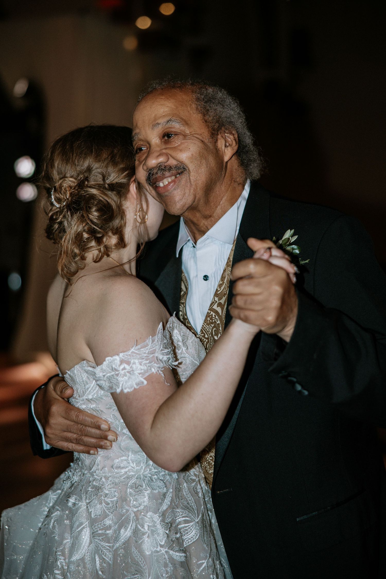 Bride and older gentleman sharing a joyful father-daughter dance at a wedding reception at Urban Artifact in Cincinnati, Ohio