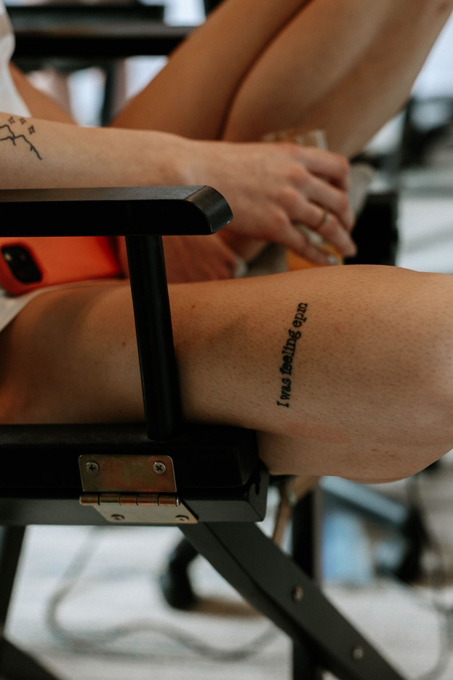 Close-up of leg tattoo reading 'I was betting on you' on woman sitting in chair.