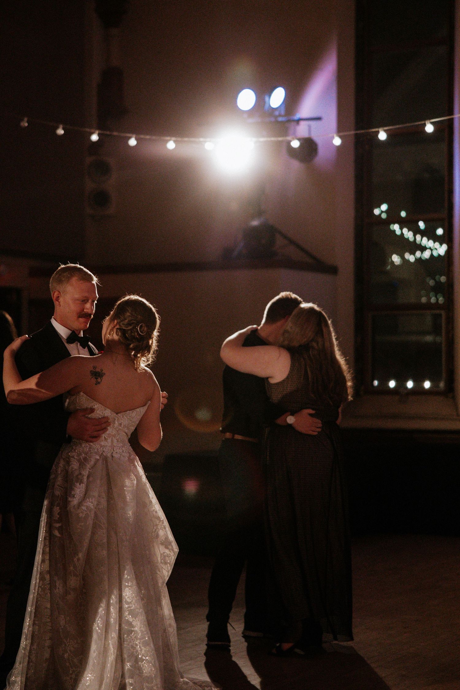 Bride and groom share first dance under string lights at elegant wedding reception in Cincinnati, Ohio