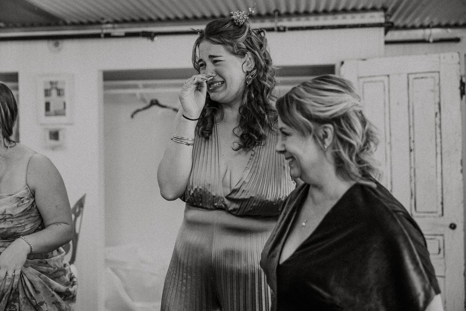 Two women sharing an emotional moment in black and white wedding preparation photo.