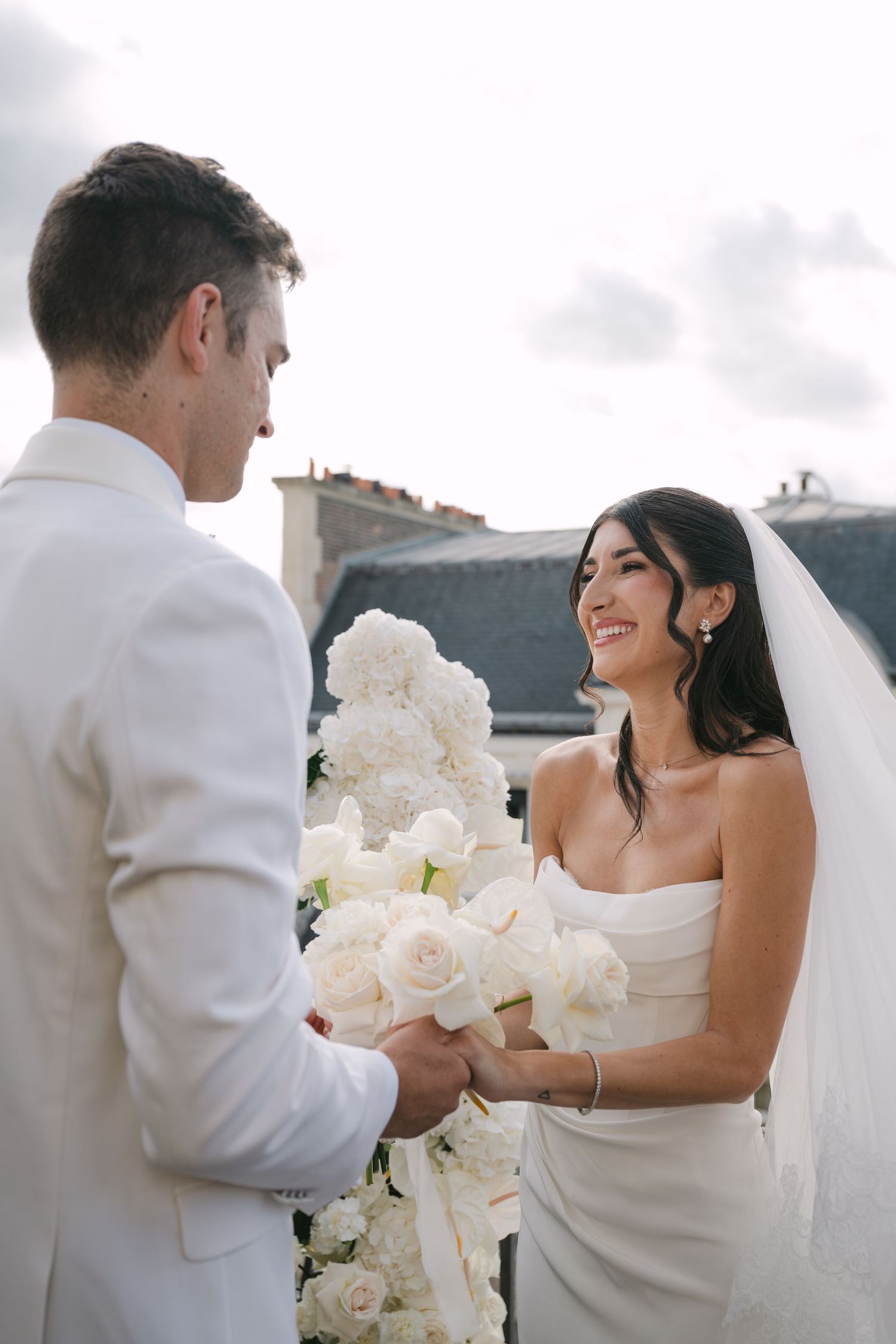 A romantic wedding moment captured in a series of four photos showing the couple with white roses against a scenic backdrop.