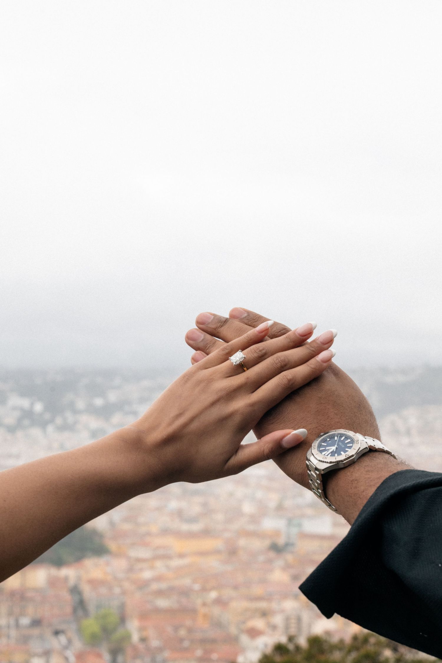 A romantic proposal moment overlooking a coastal mountain landscape with misty views of the Mediterranean Sea below.