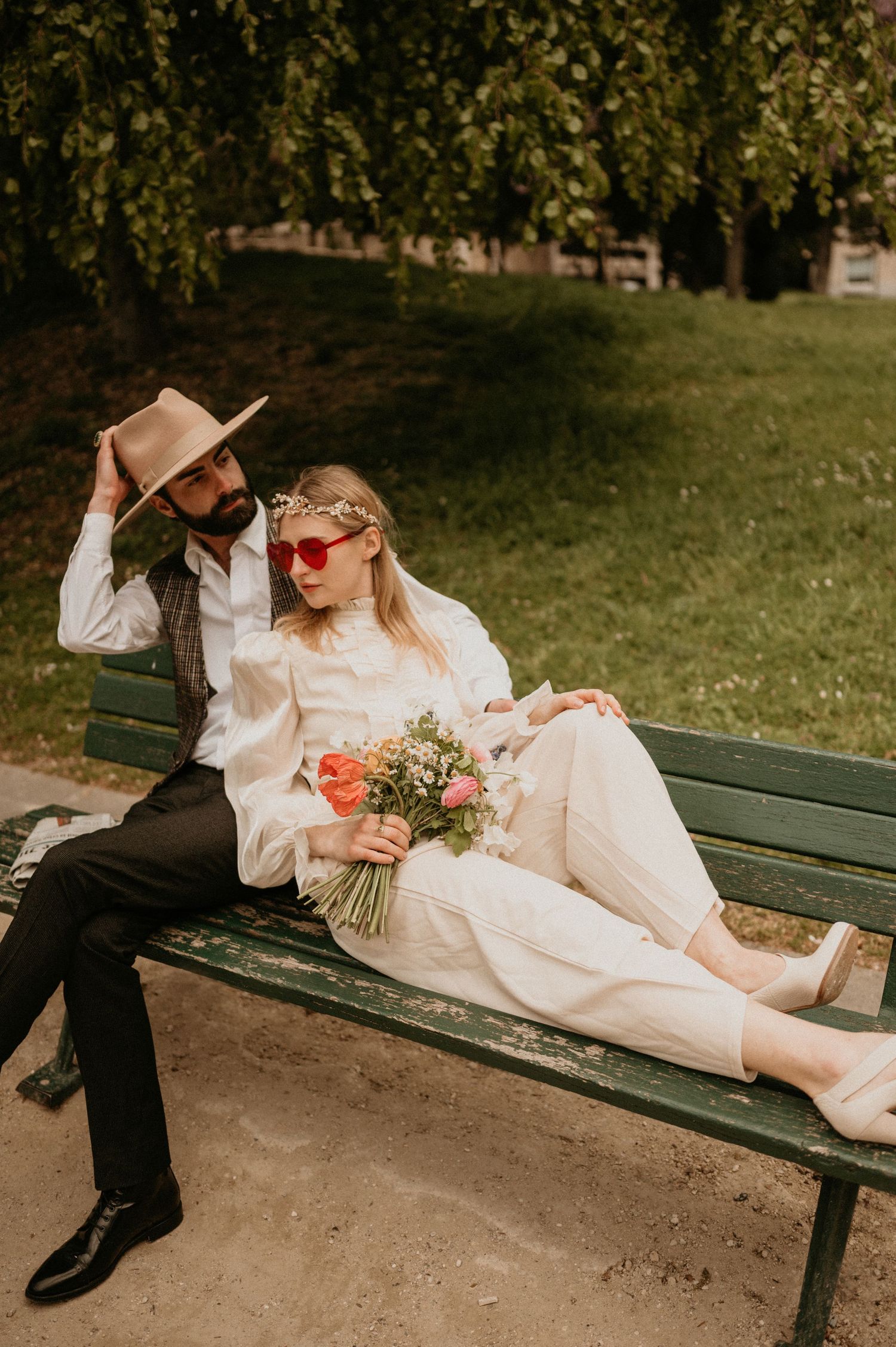 Romantic scene on park bench with flowers and fashionable accessories.