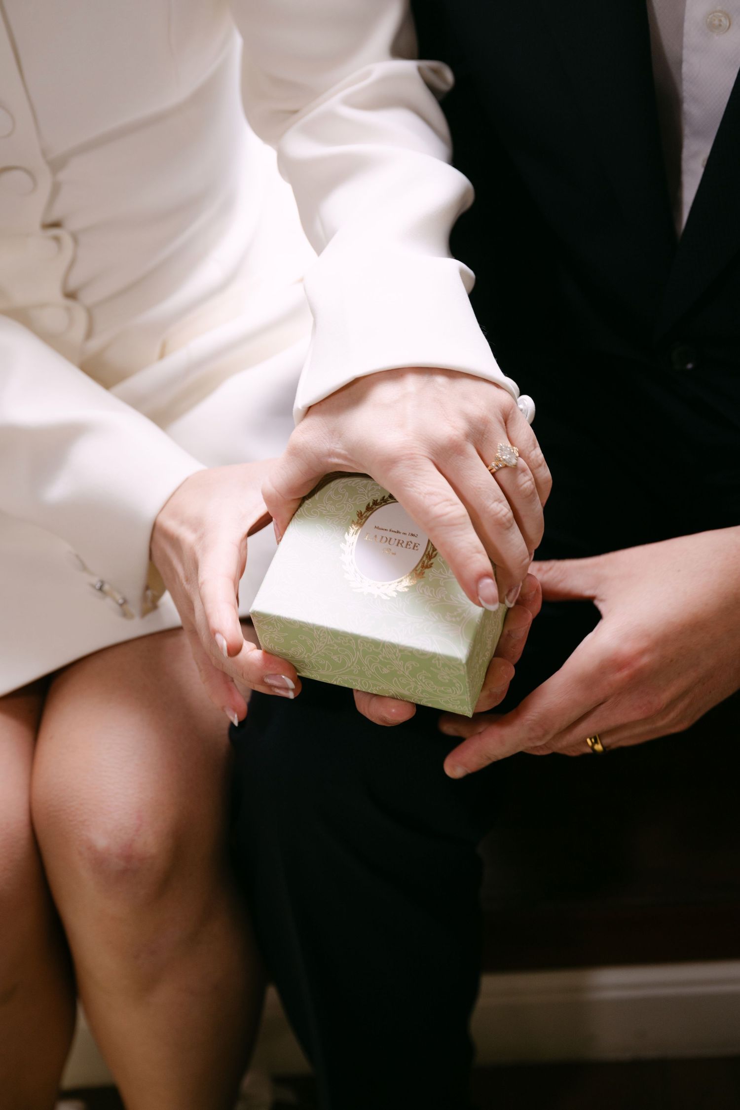 A series of hands holding and opening a small book or booklet against a dark background.