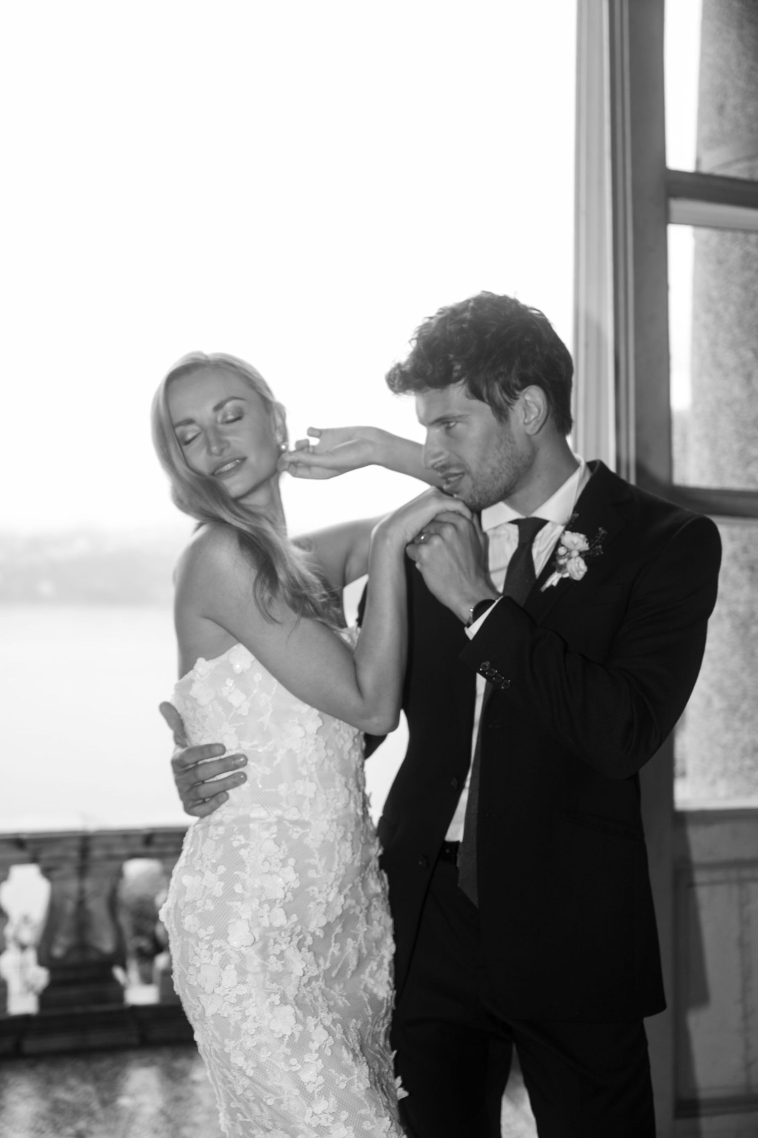 Two hands touch tenderly against a blurry cityscape backdrop, with one person wearing an elegant wristwatch.