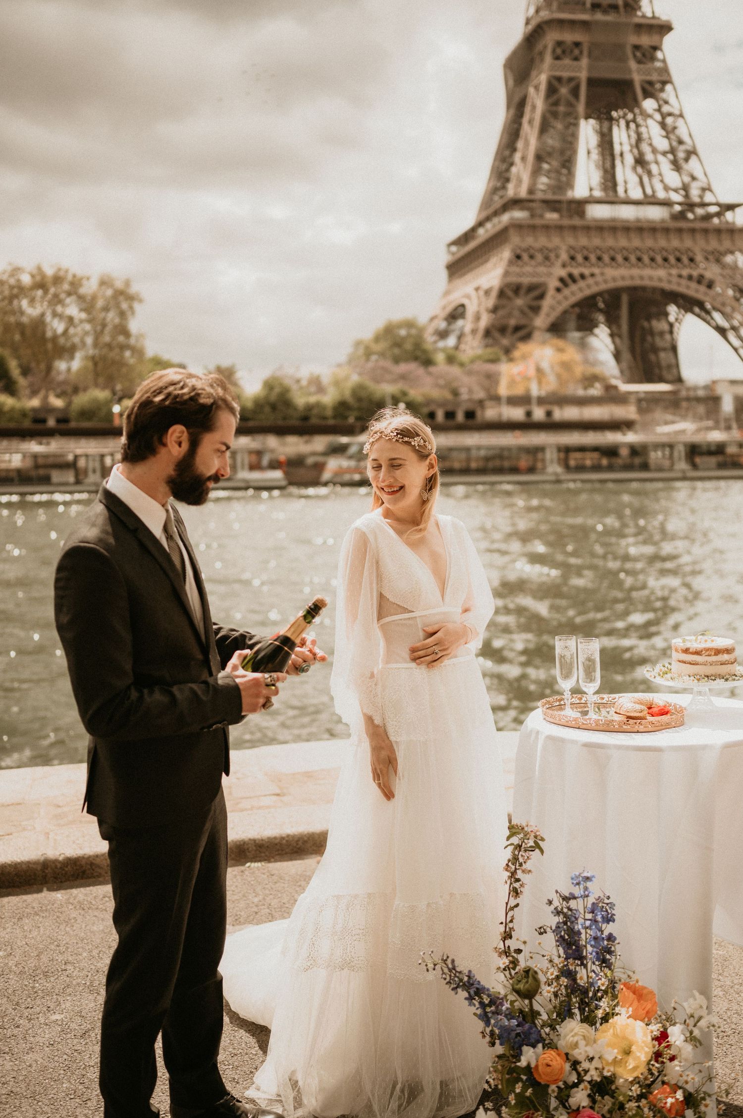 A couple celebrates with champagne during their intimate Paris wedding by the Eiffel Tower.