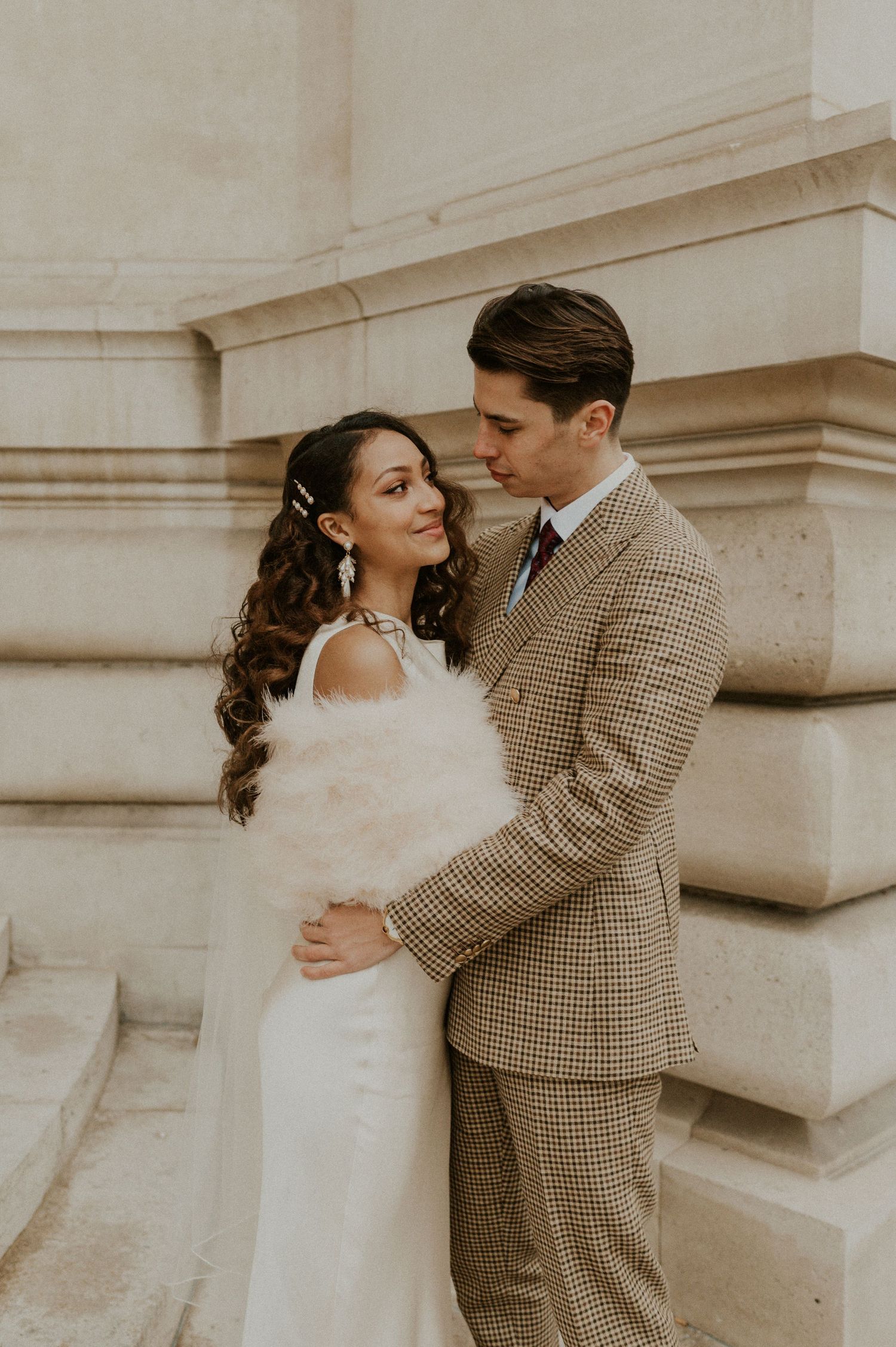 Romantic wedding portrait against classic stone architecture.