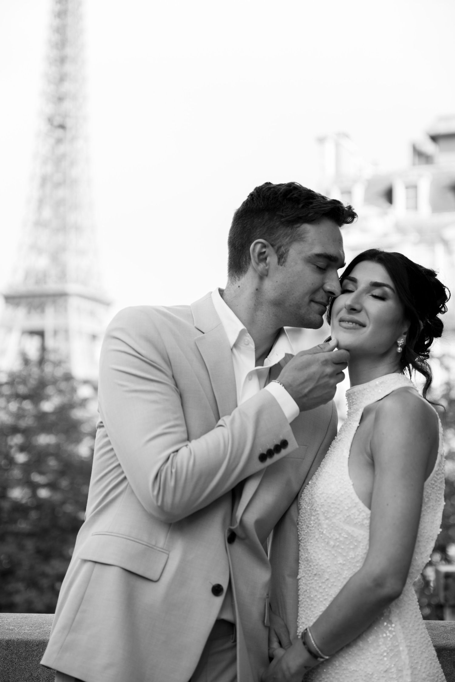 A romantic wedding couple shares intimate moments in a series of black and white portraits.