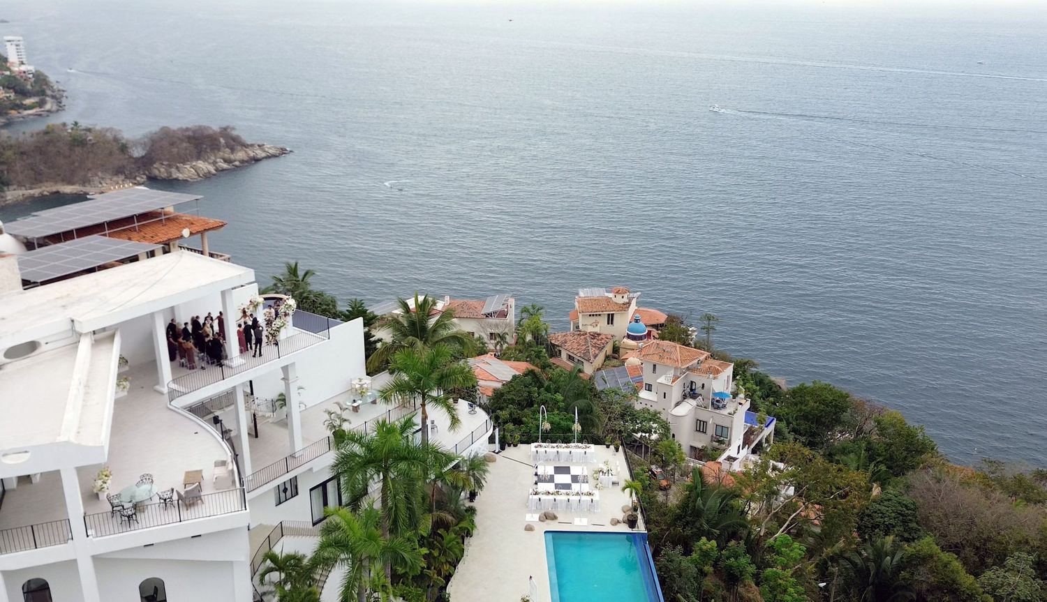 Aerial view of white luxury villas with pool on cliffside overlooking the Pacific Ocean in Puerto Vallarta, Mexico.