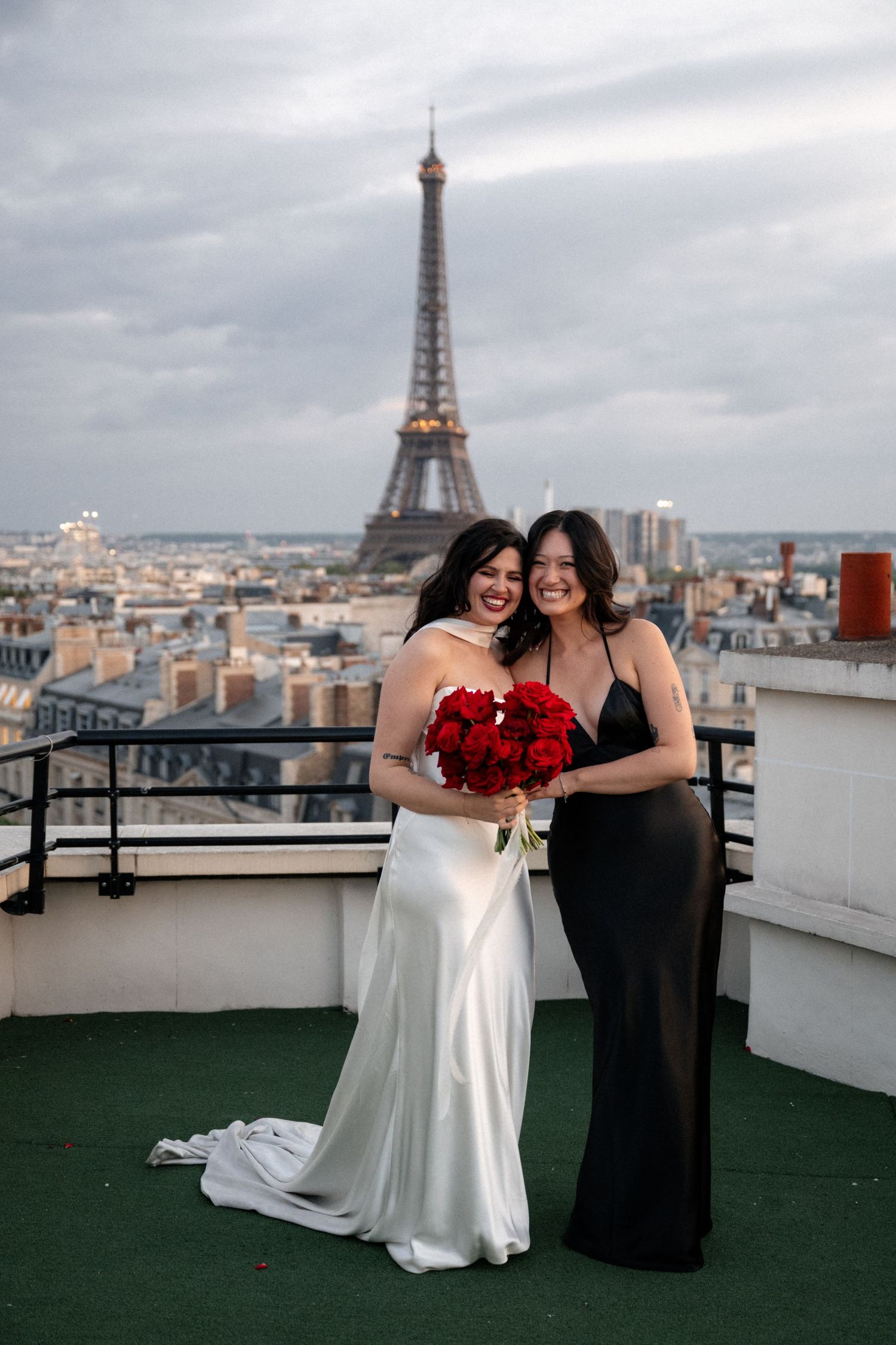 Scenic rooftop view of Paris with the Eiffel Tower visible in the background on a cloudy day.