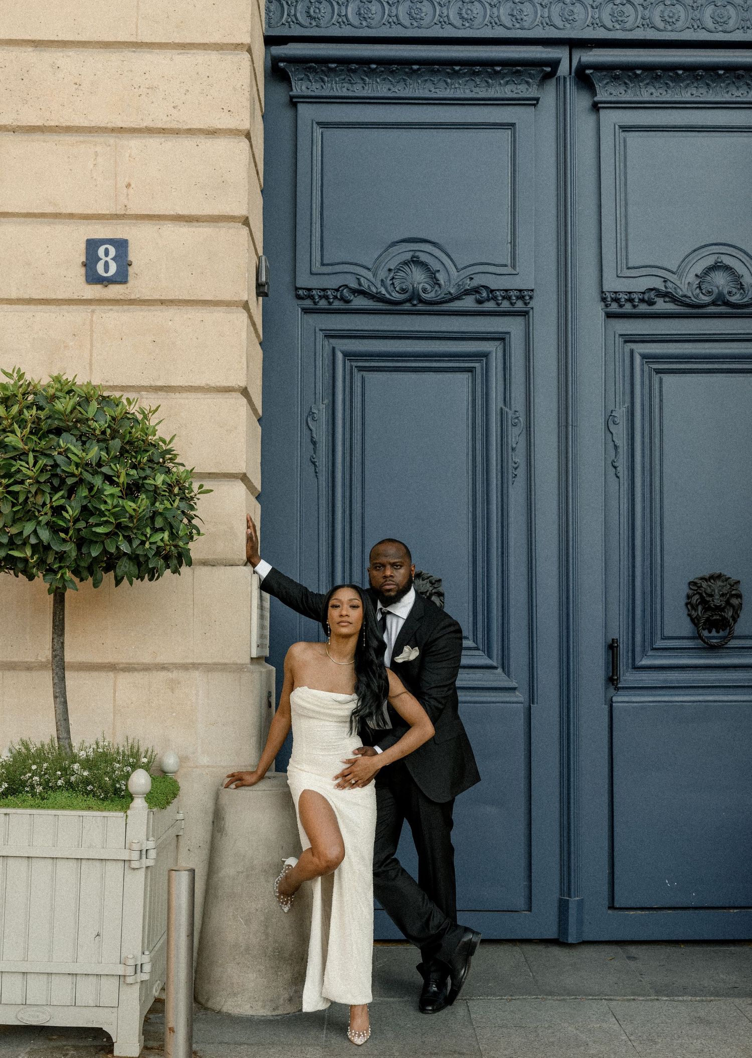 A stylish pose against an ornate blue Parisian door numbered 8.