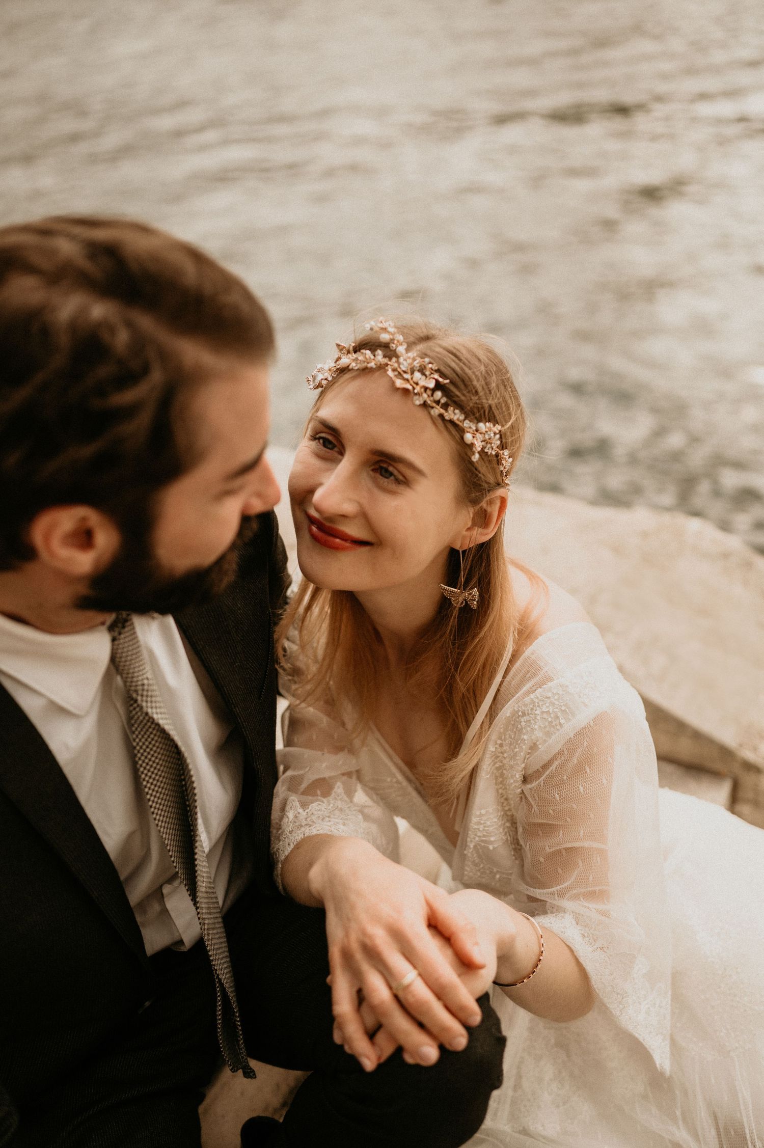 Romantic close-up of newlyweds sharing an intimate moment by the river in Paris.