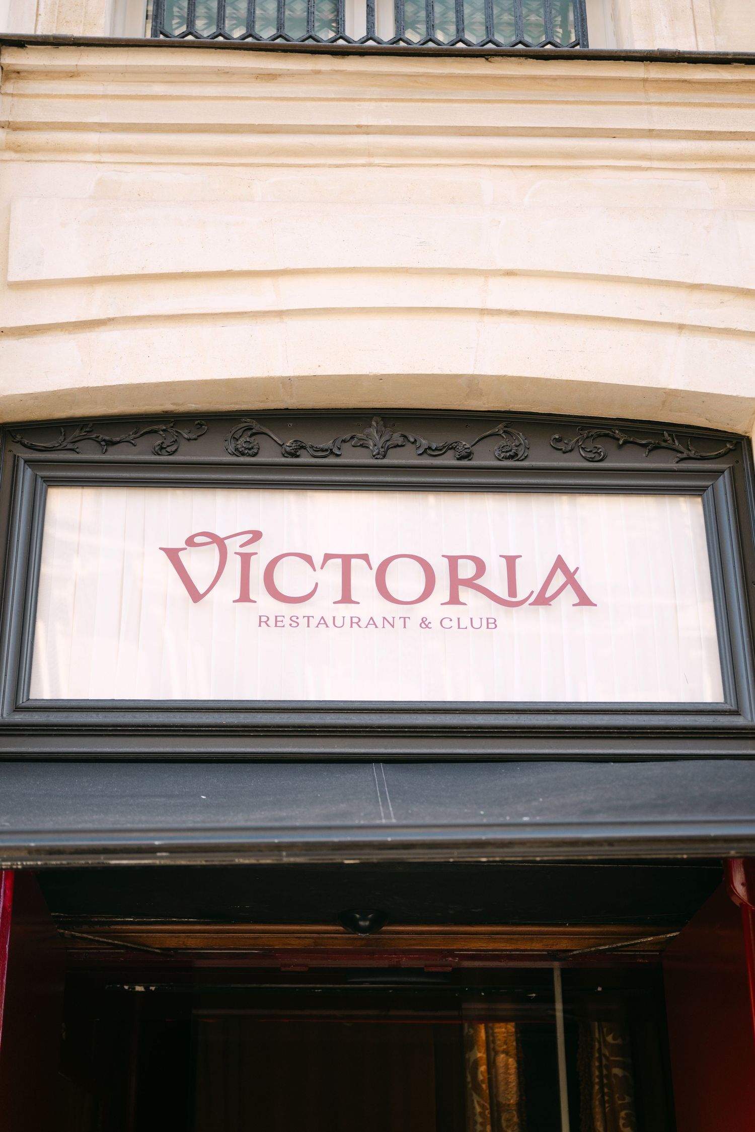 Victoria Restaurant and Club sign on classic Parisian building facade entrance.