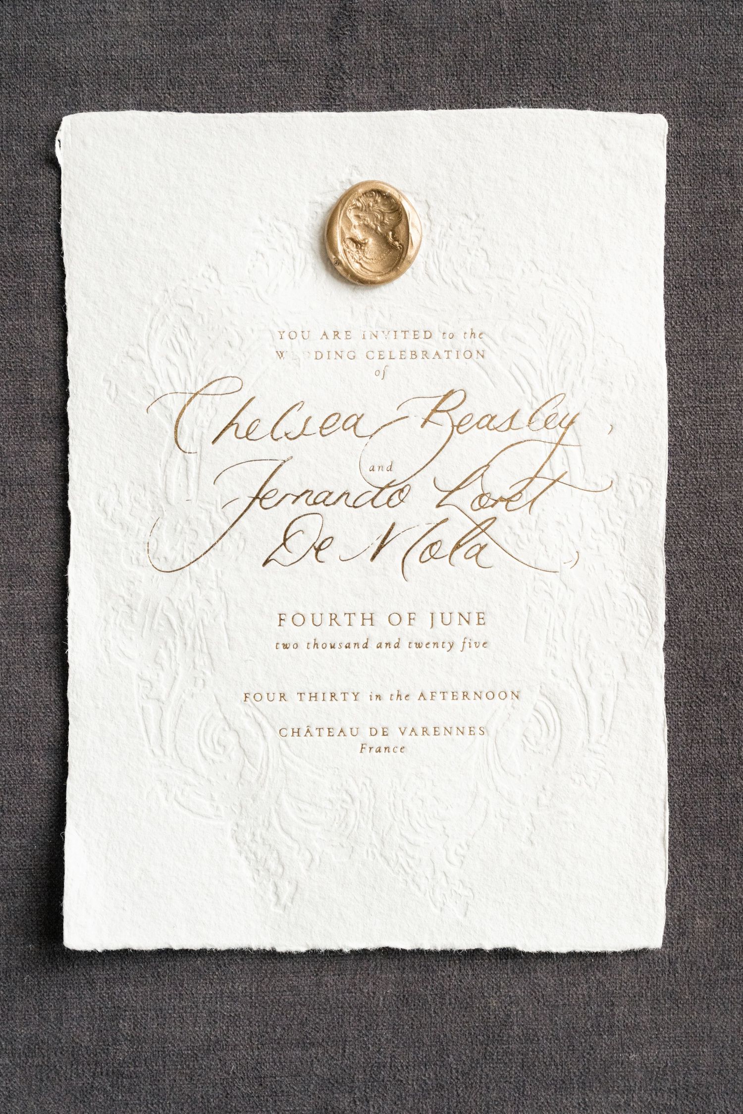 Elegant wedding invitation on textured white paper with gold wax seal and calligraphy text for a June celebration.