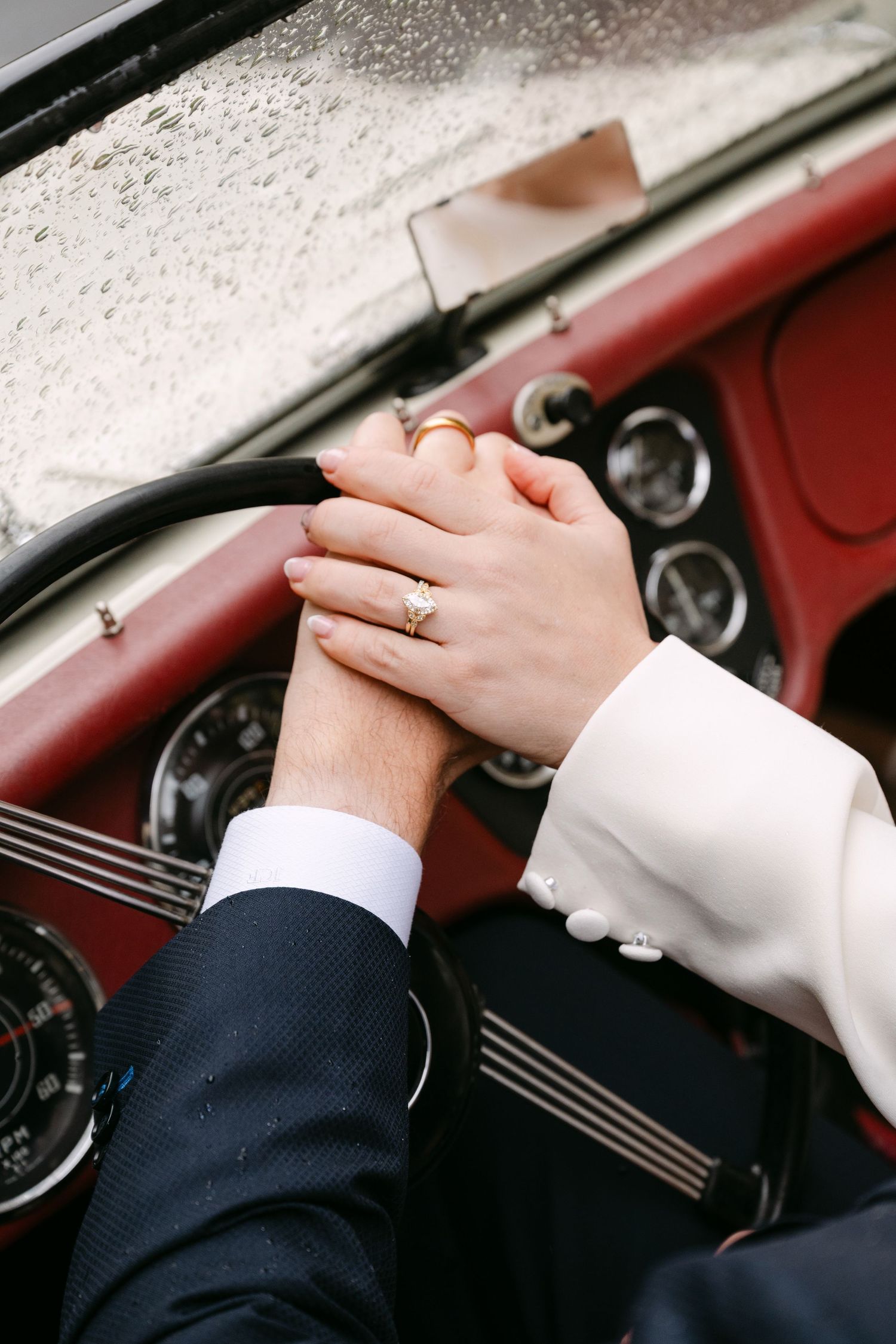 A close-up sequence of hands with wedding rings clasped together against a dark background.