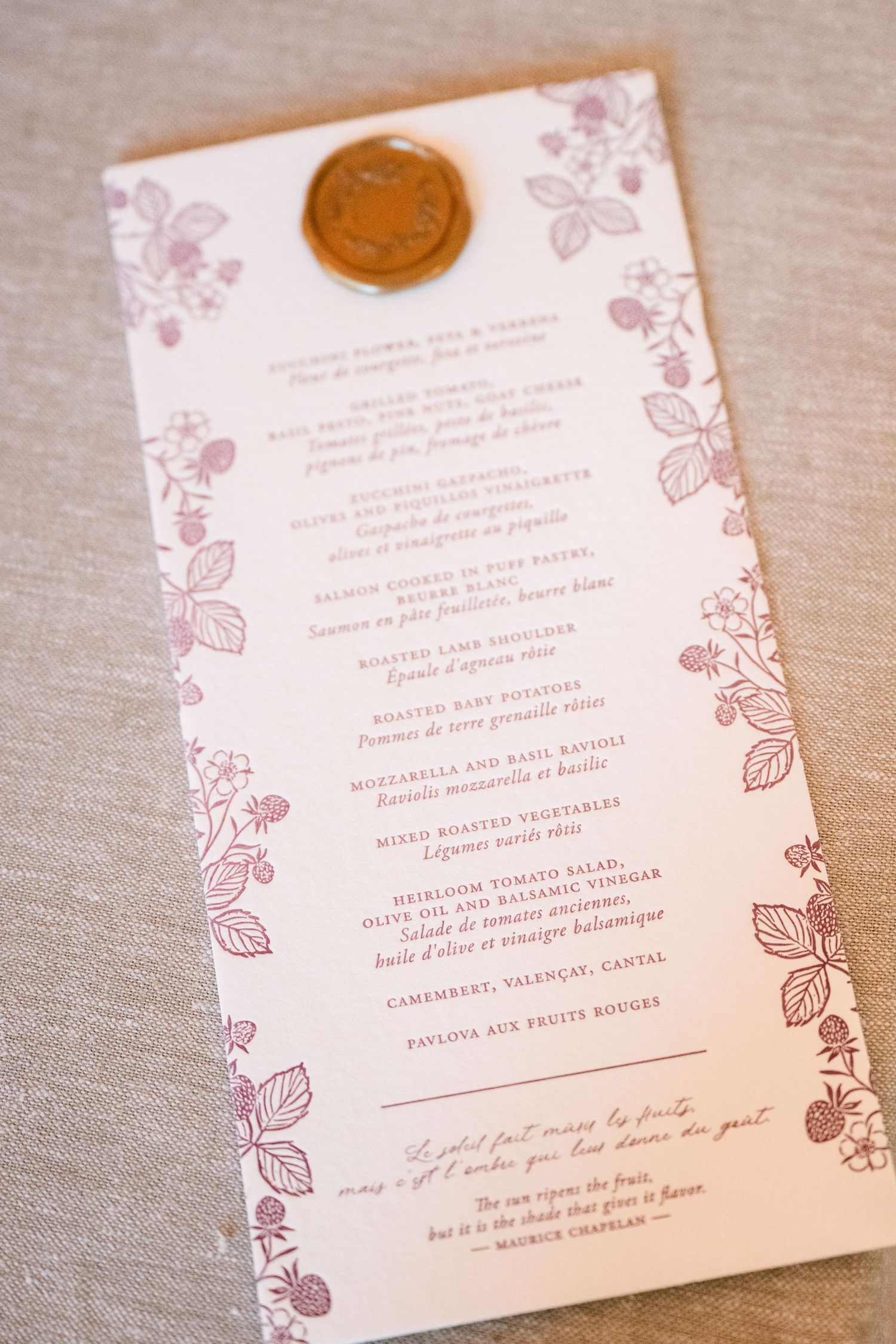 Elegant wedding menu card with wax seal, floral botanical prints, and handwritten script on cream paper.