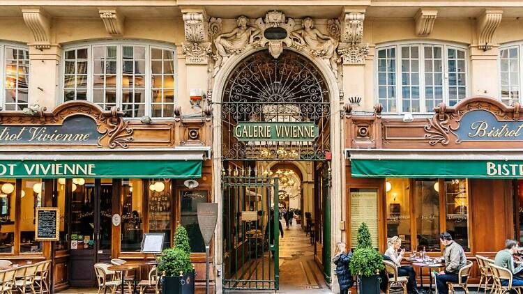 Historic Parisian passage entrance with charming cafes and ornate architectural details.