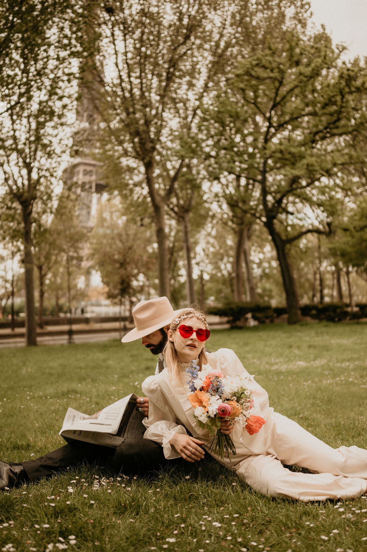 Whimsical park scene with retro-styled photo near Eiffel Tower featuring bright flowers and heart sunglasses.