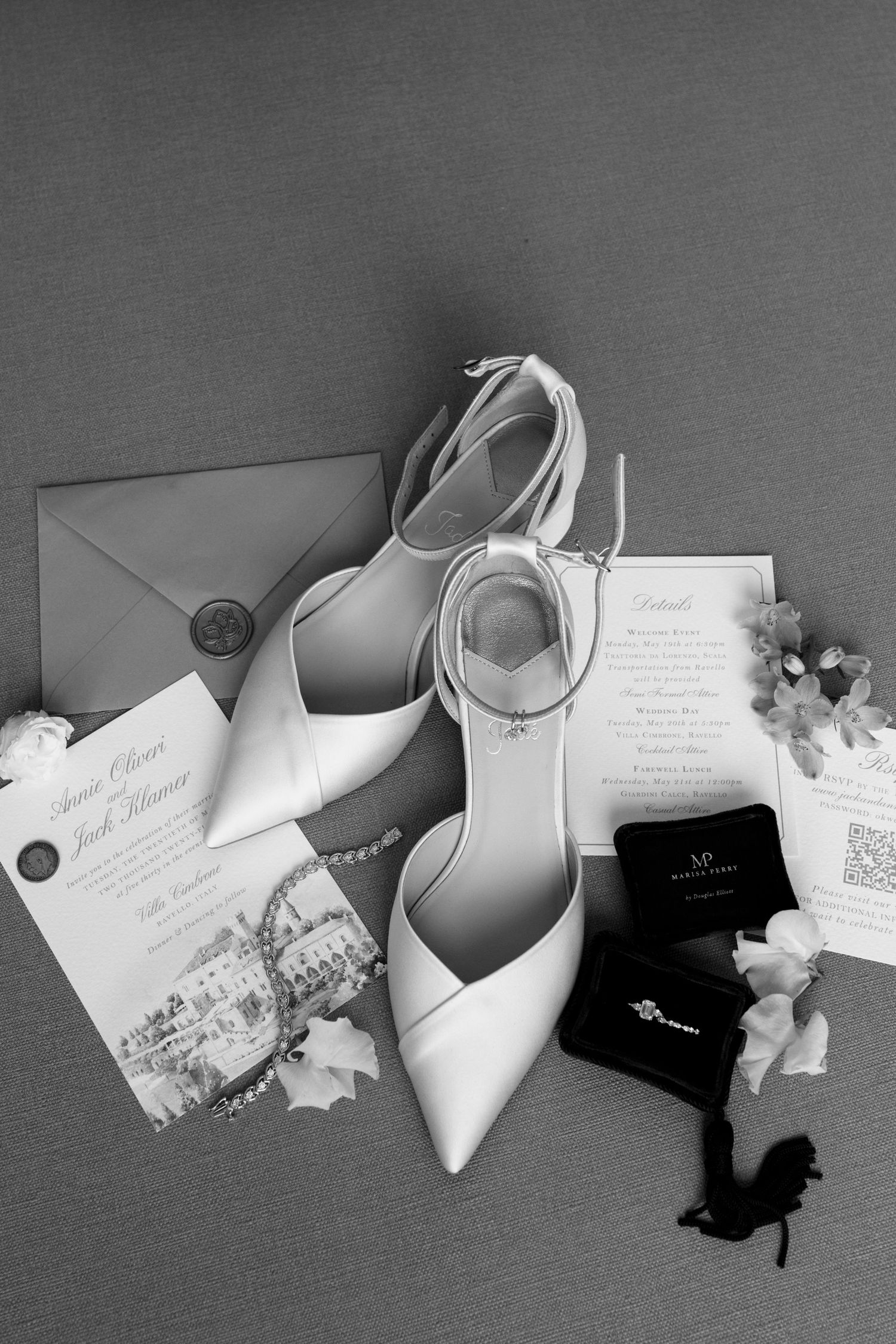 Black and white flat lay of bridal heels, wedding invitations, and accessories for an Italian destination wedding.