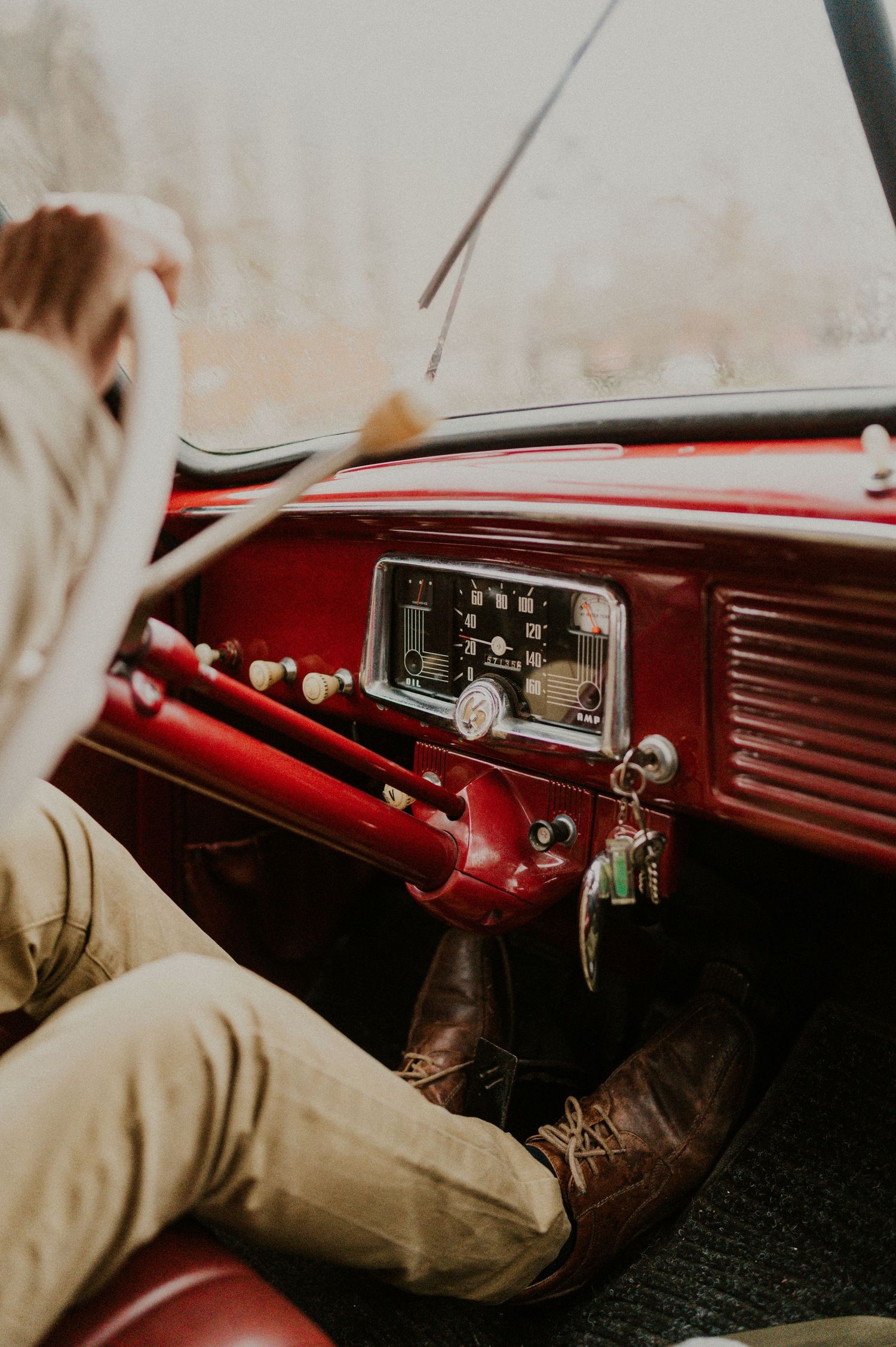 Vintage car interior showing red dashboard and classic radio controls.