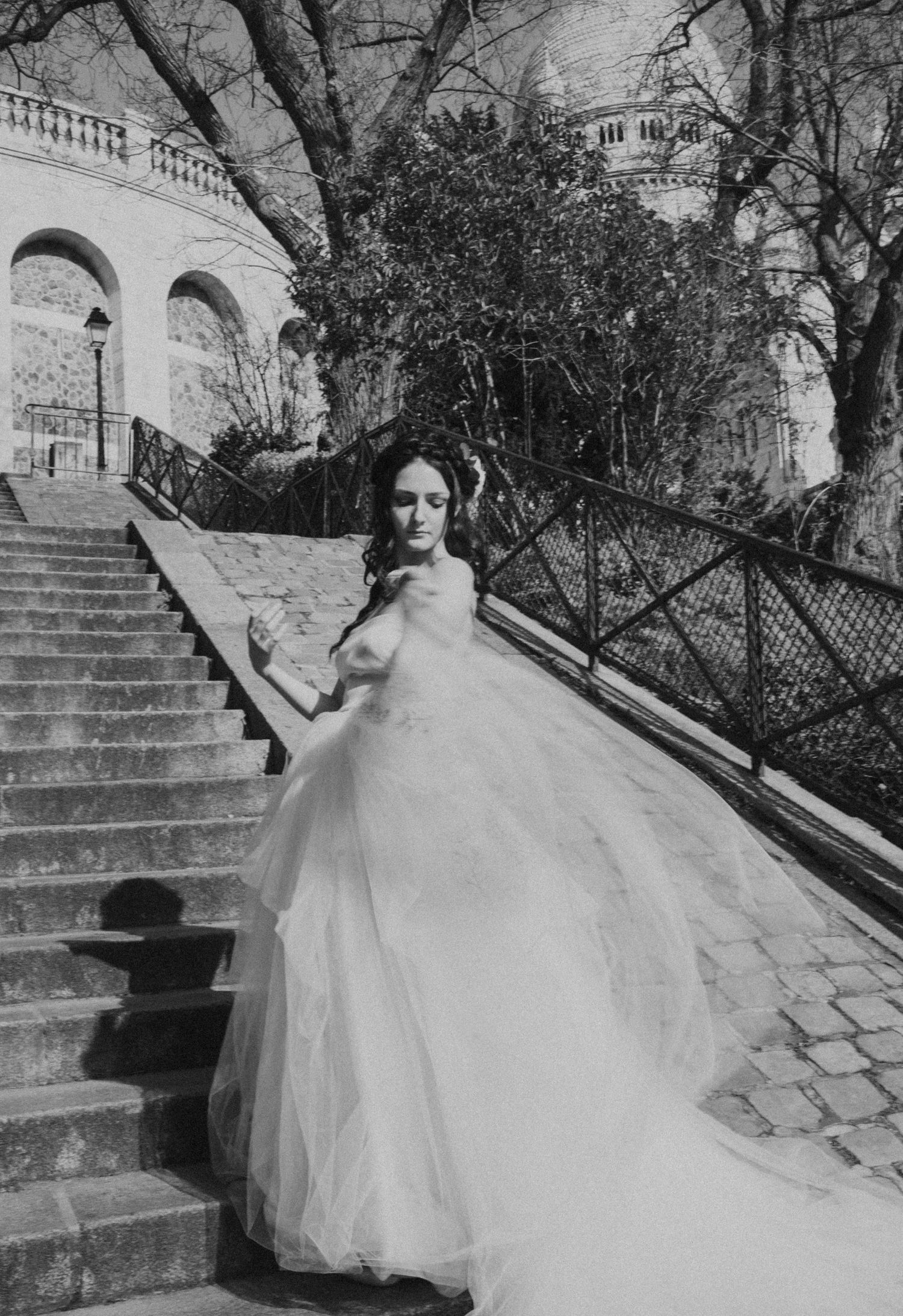 Dramatic black and white bridal photo captured on ornate stone staircase.