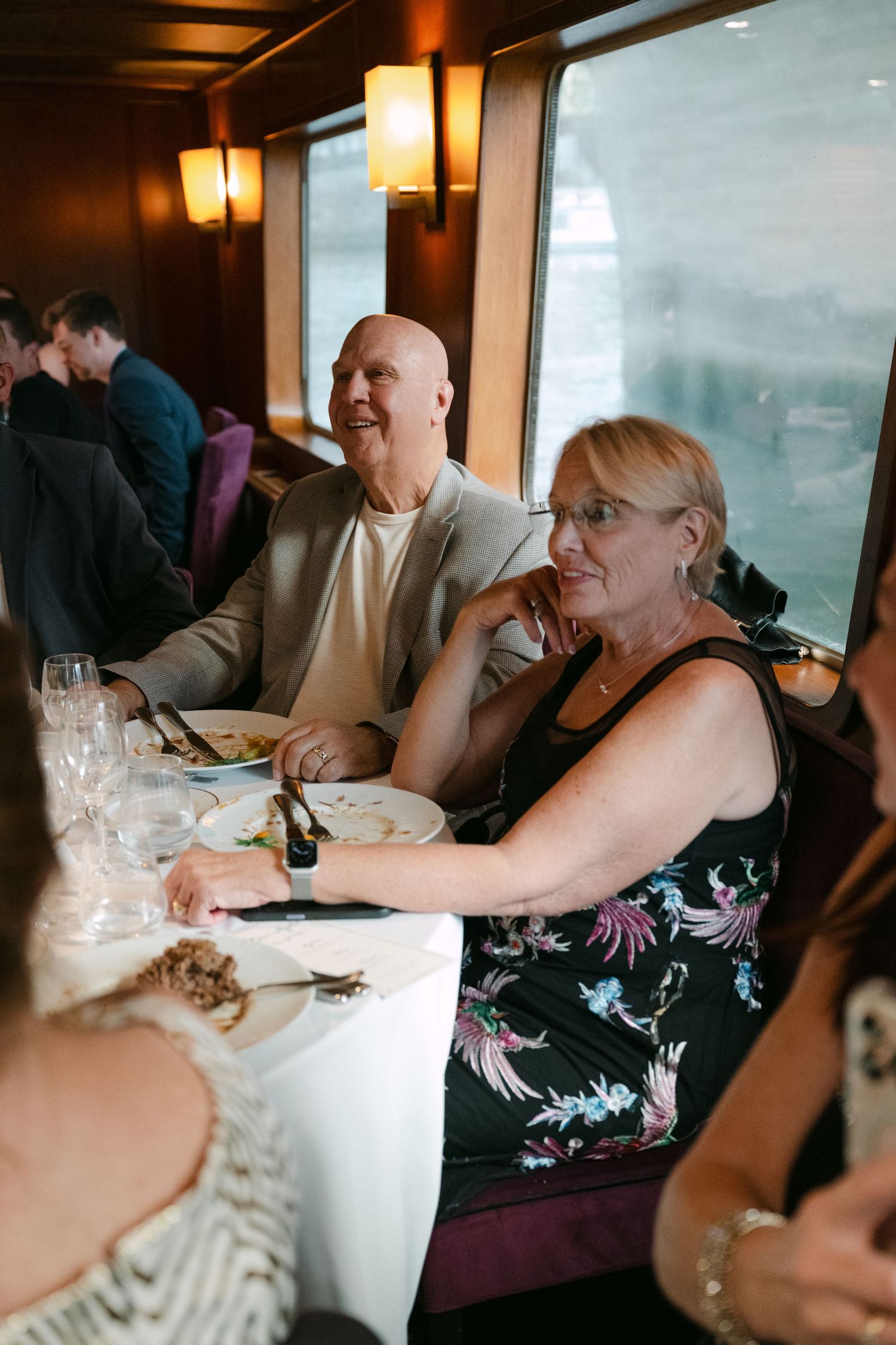 Guests seated at a dimly lit restaurant with warm lighting and dark wood paneling.