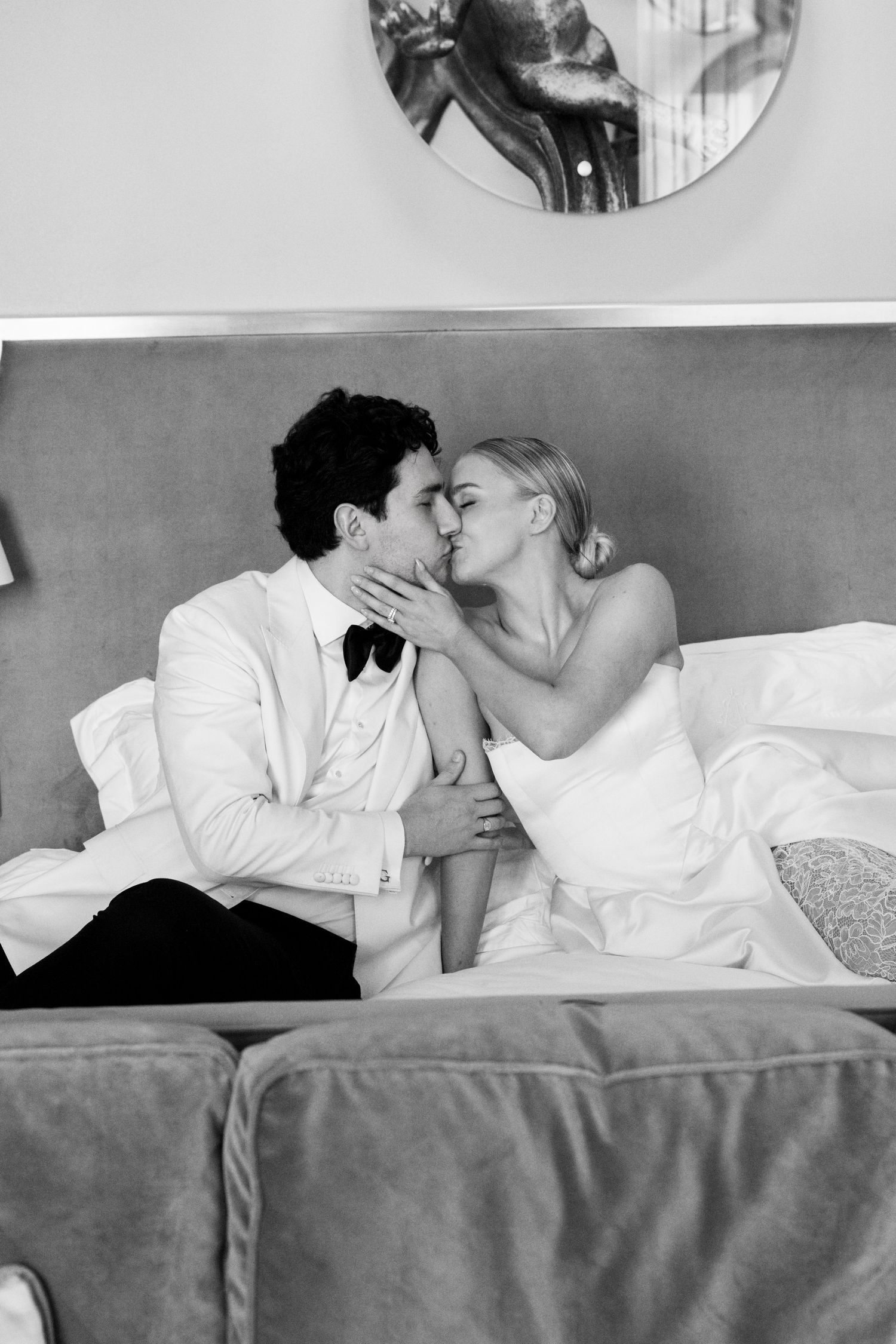 A romantic black and white photo series showing a couple sharing intimate moments while lying in bed together.