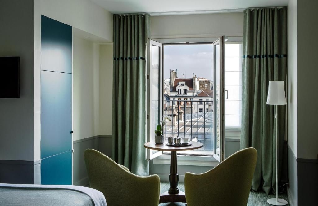 Luxurious hotel room with vintage decor, ornate moldings, and a window offering views of the Eiffel Tower in Paris.