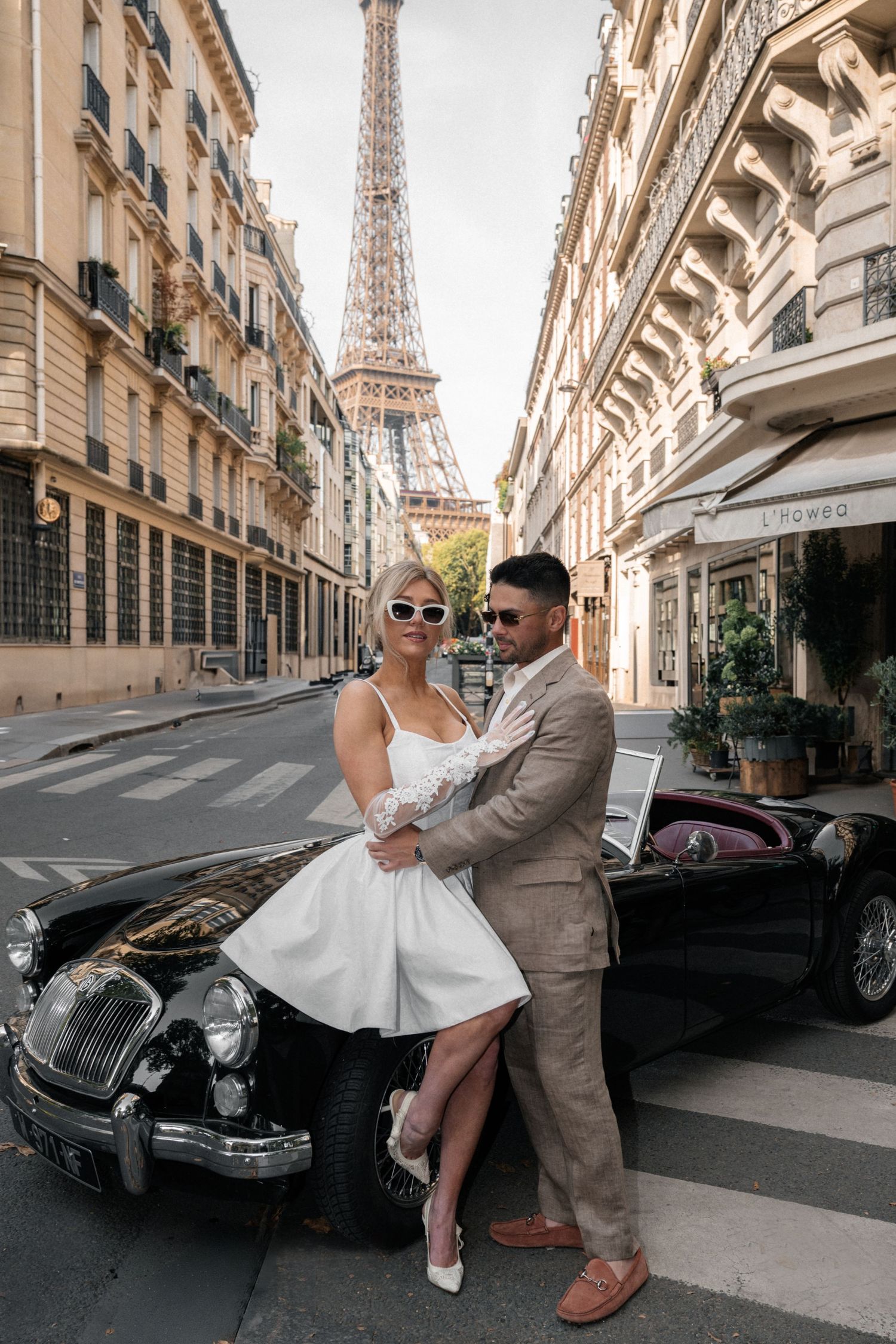 Eiffel Tower photoshoot with a vintage car and a couple posing at sunrise