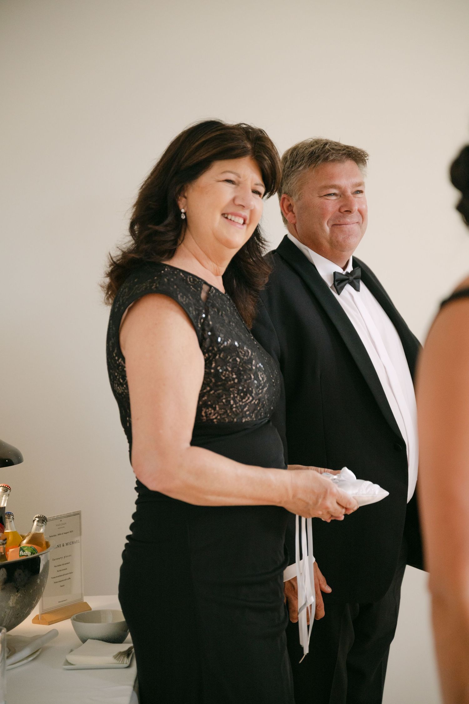 Wedding guests mingle during cocktail hour in formal black tie attire.