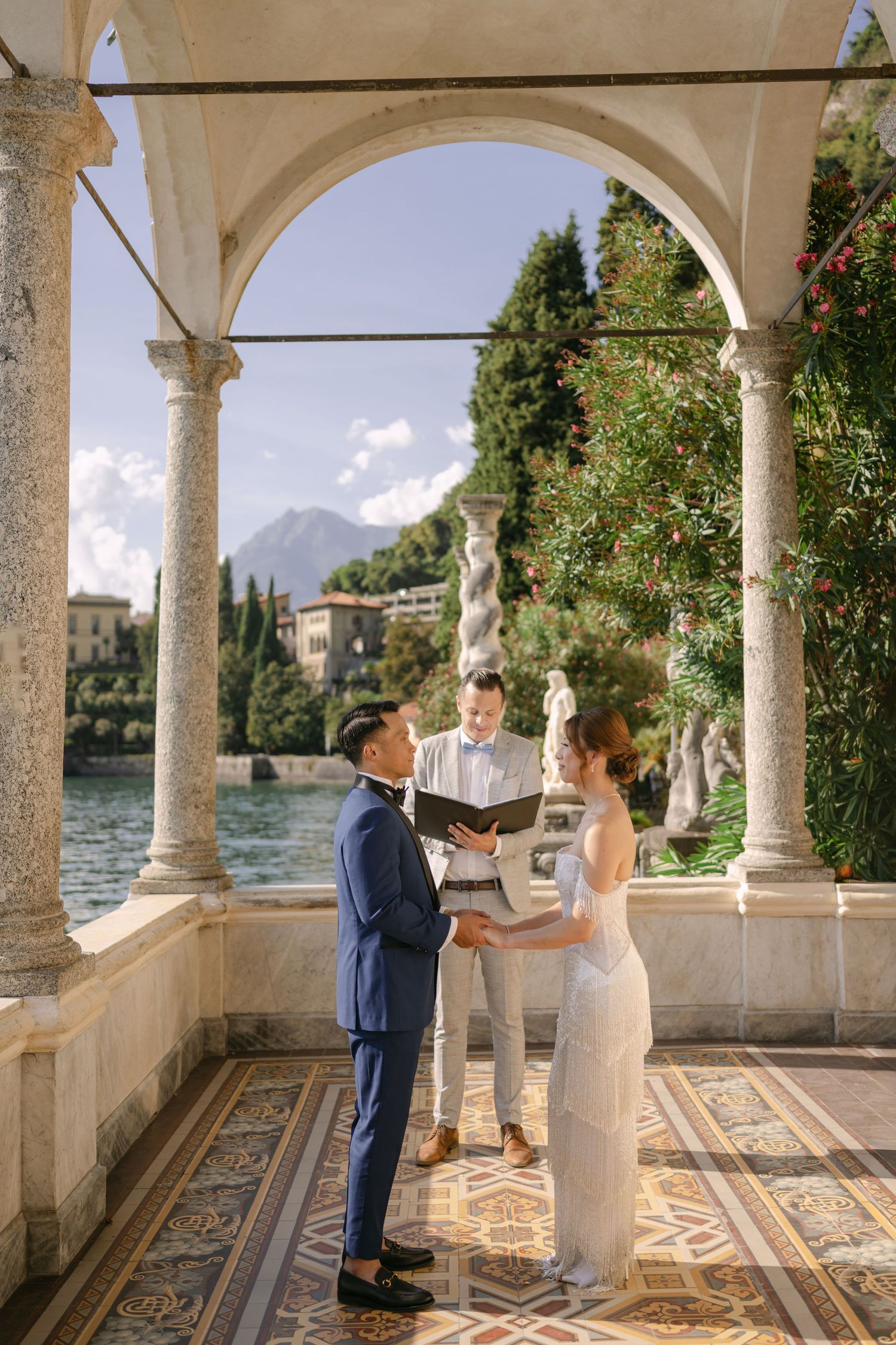 Couple exchanges vows during an elegant lakeside wedding ceremony at Villa Monastero, Lake Como, Italy.