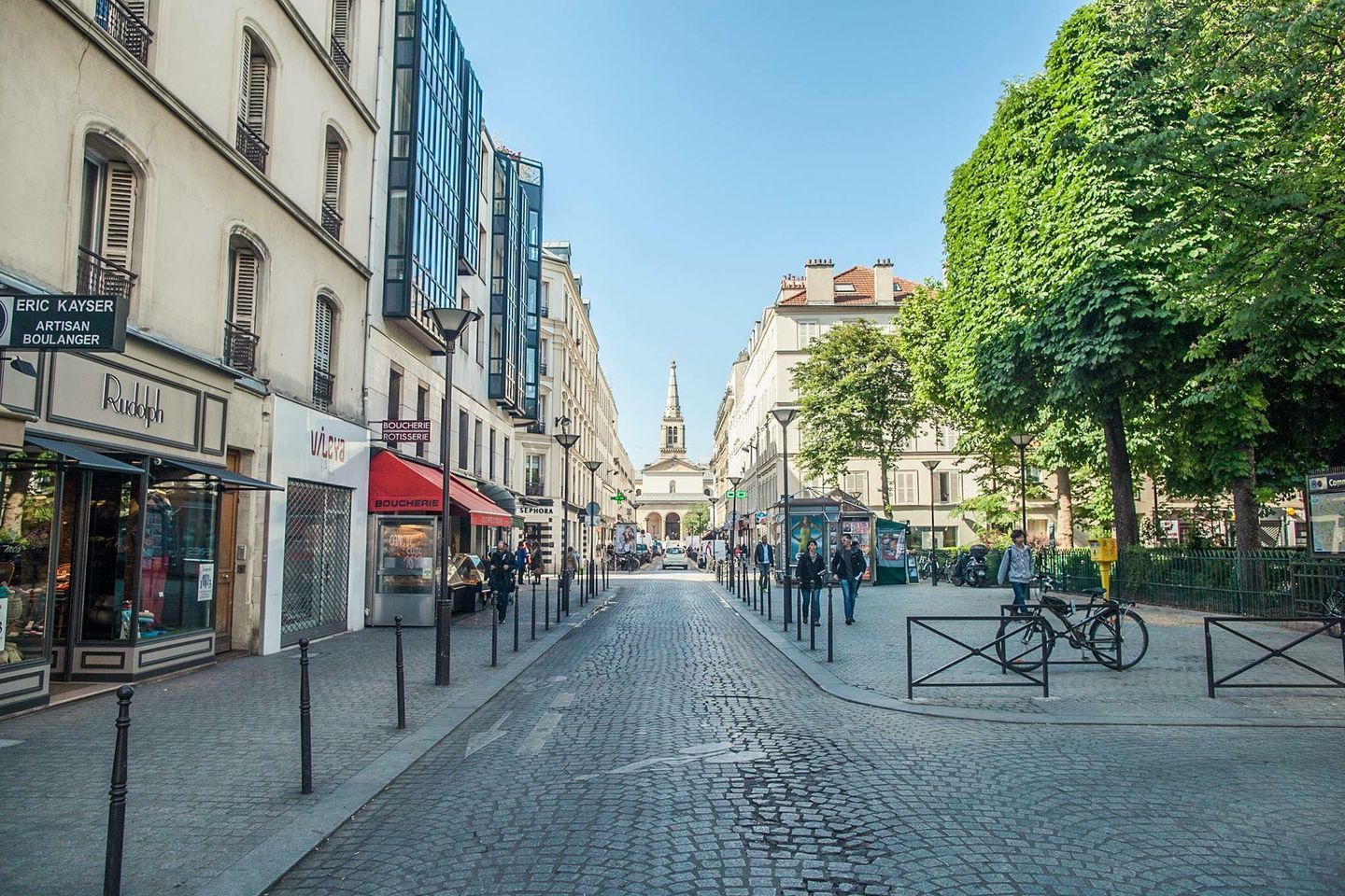 Charming cobblestone street in Paris lined with traditional buildings and shops.